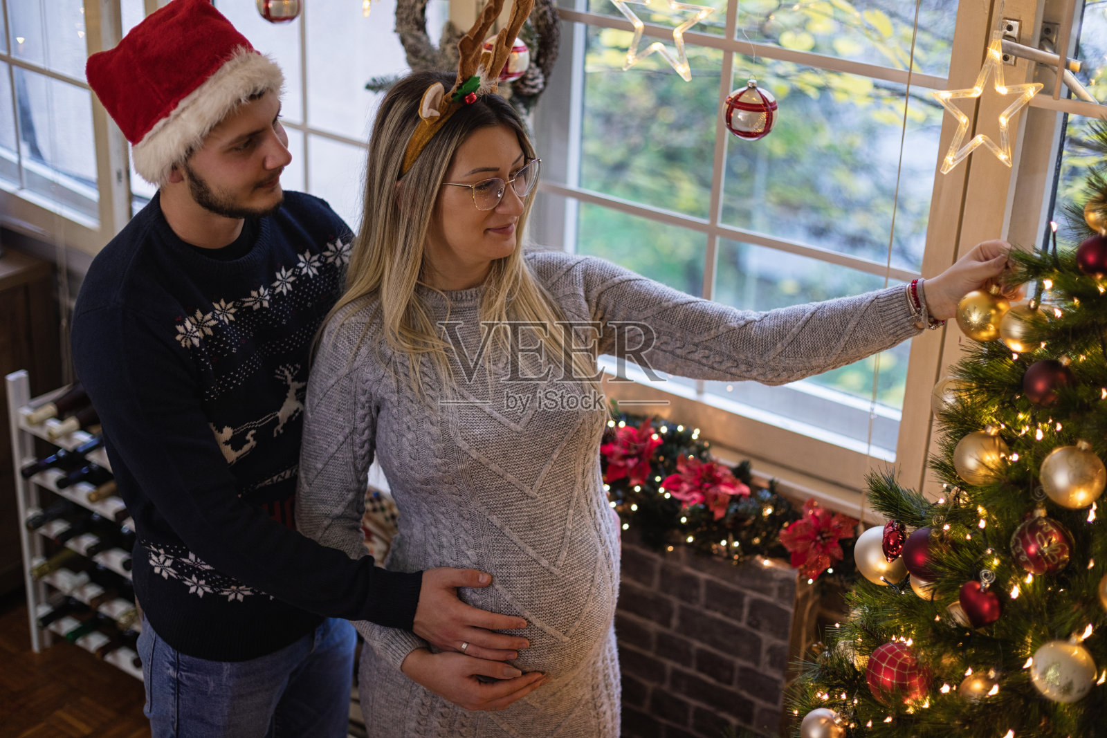 一对年轻夫妇正在装饰圣诞树照片摄影图片