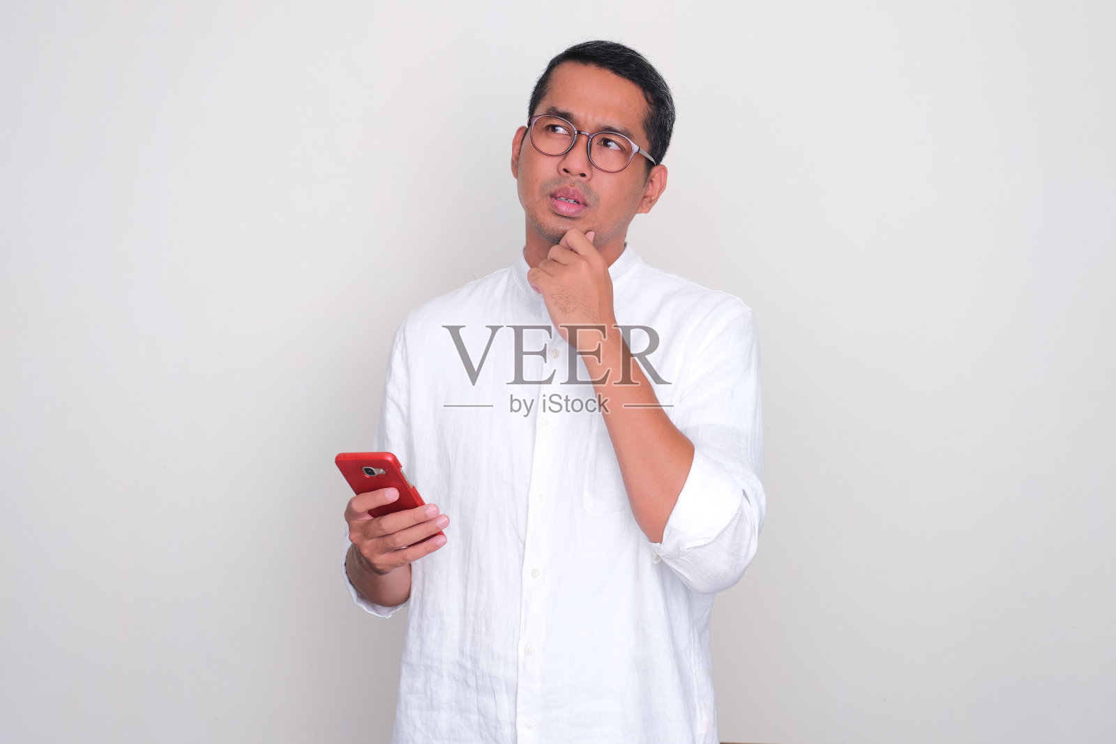 亚洲成年男子拿着手机在想什么照片摄影图片