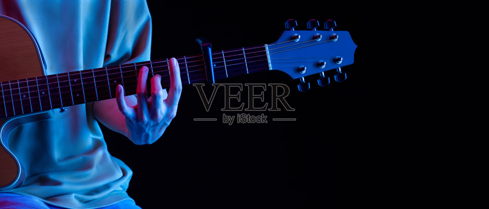 在灯光和声音中演奏黑色背景吉他,这是生活中的爱好照片摄影图片