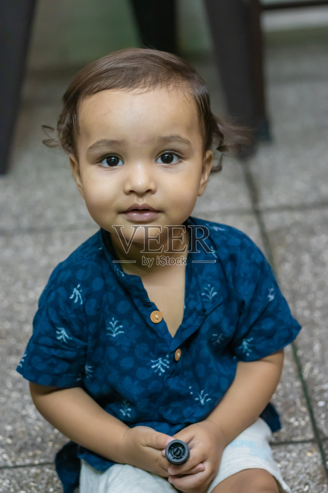 蹒跚学步的小男孩表情可爱,随意出现在室内照片摄影图片