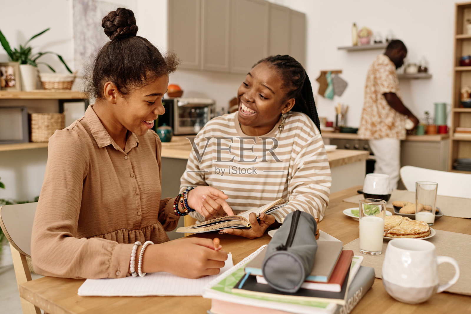 母亲帮助女儿做家庭作业照片摄影图片