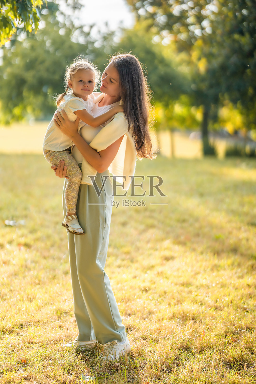 在欧洲布拉格的秋天公园里,年轻的妈妈和可爱的小女儿在一起玩耍照片摄影图片