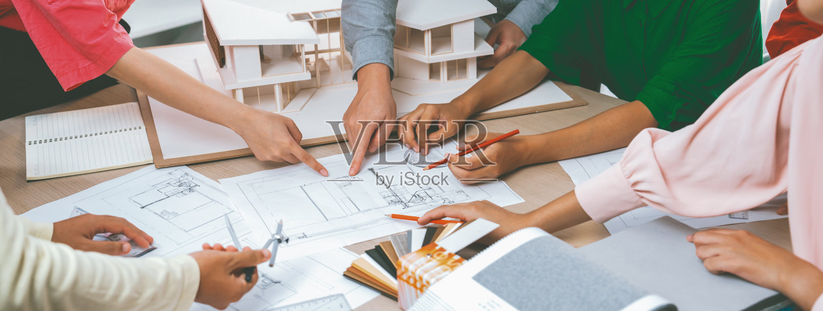 熟练的建筑师团队讨论房屋建造。前视图。斑叶。照片摄影图片