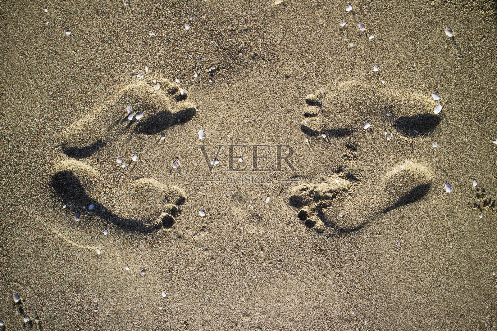 照片记录了沙地上的人类脚印照片摄影图片