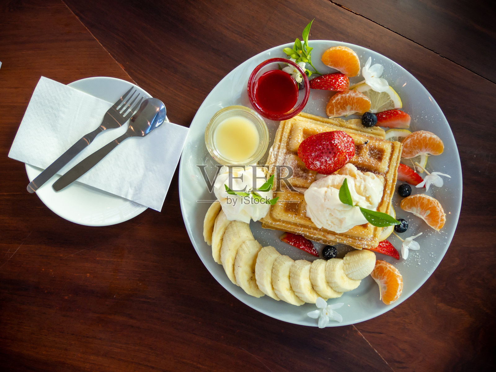 木桌上的华夫饼、冰淇淋和水果,俯视图照片摄影图片