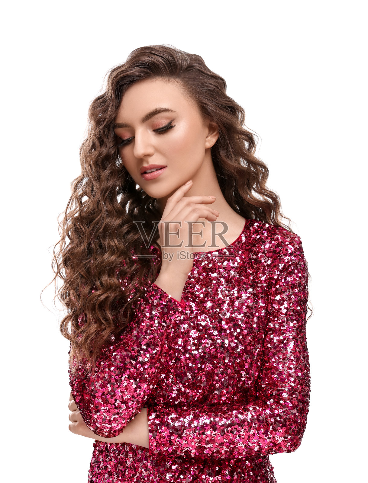 漂亮的年轻女子,棕色卷发,身穿白色背景的粉色亮片连衣裙照片摄影图片