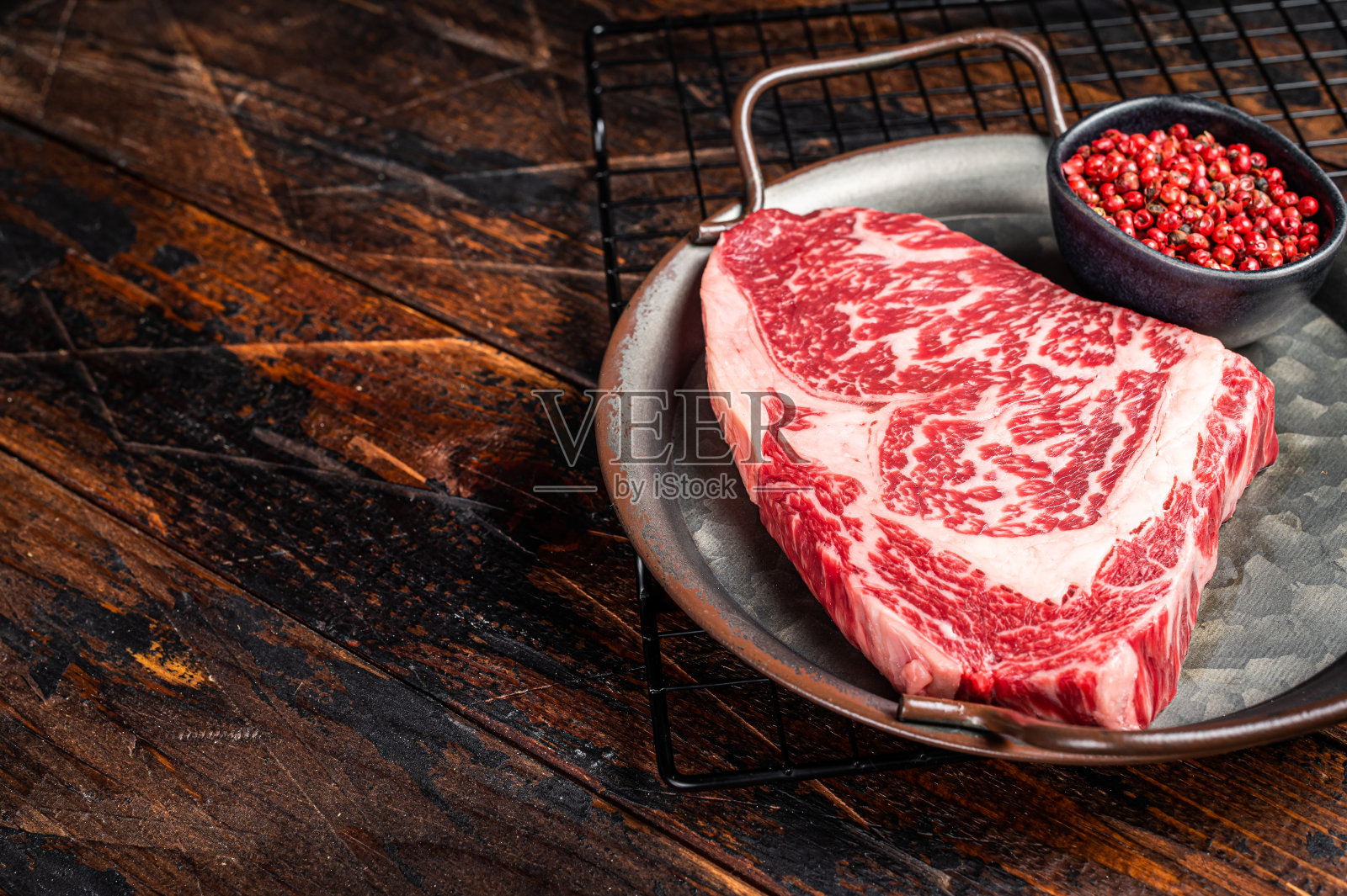 钢盘生和牛肋眼牛排。木制背景。前视图。本空间照片摄影图片