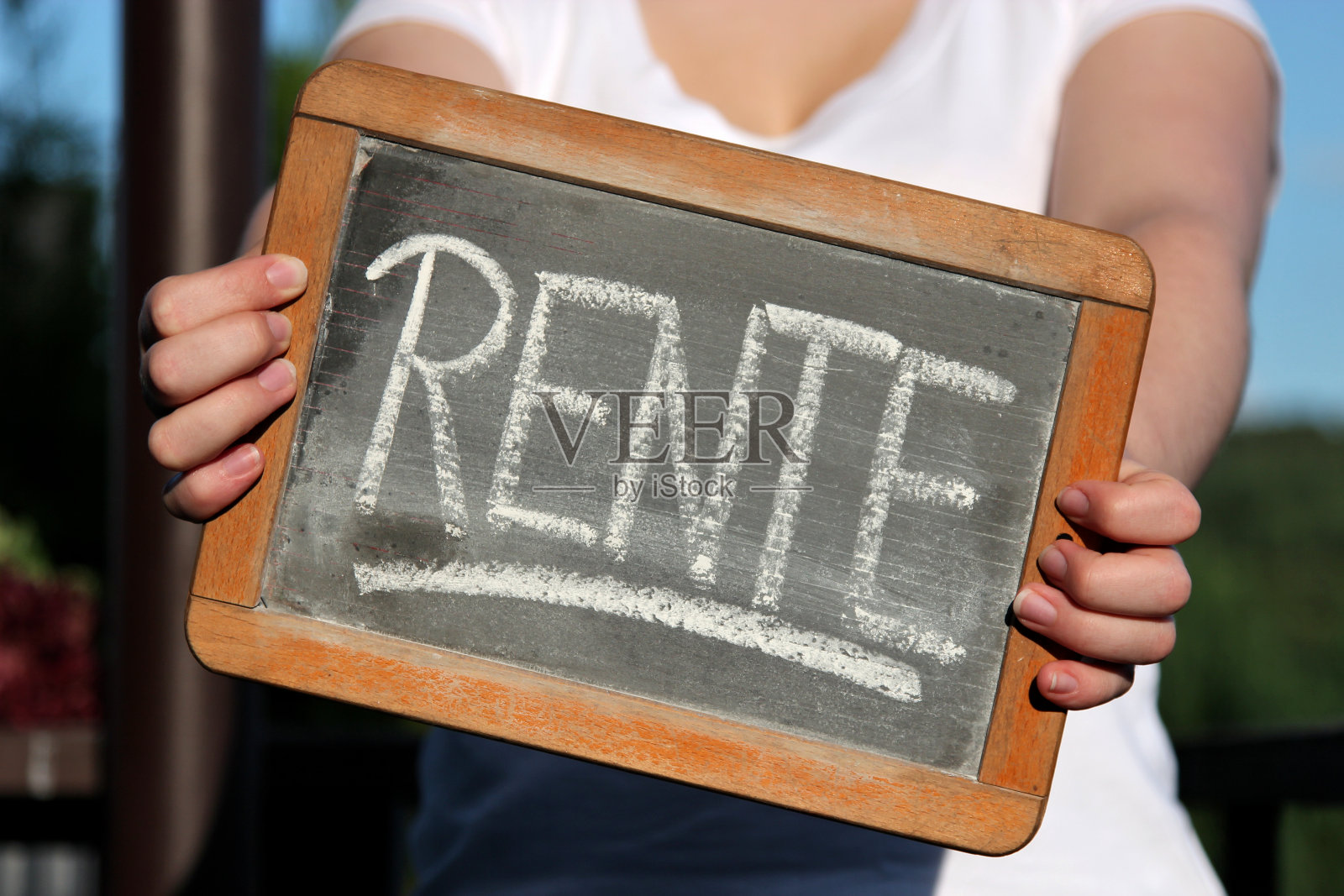一位年轻女性用粉笔在石板上写的“Rente”(德语的退休金)照片摄影图片