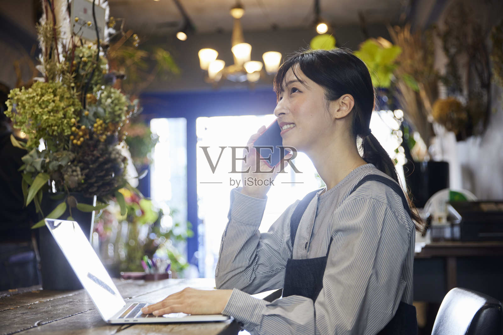 一位在花店系着围裙的日本妇女照片摄影图片