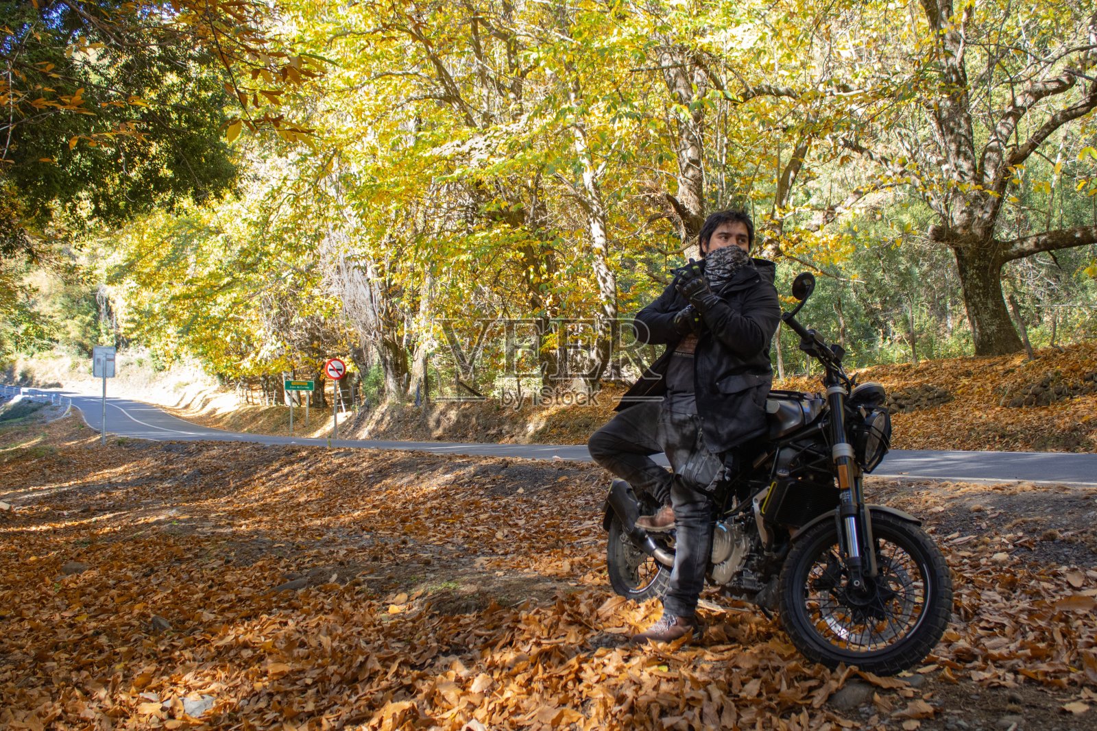 骑摩托车的人停在乡间小路上观赏秋景照片摄影图片
