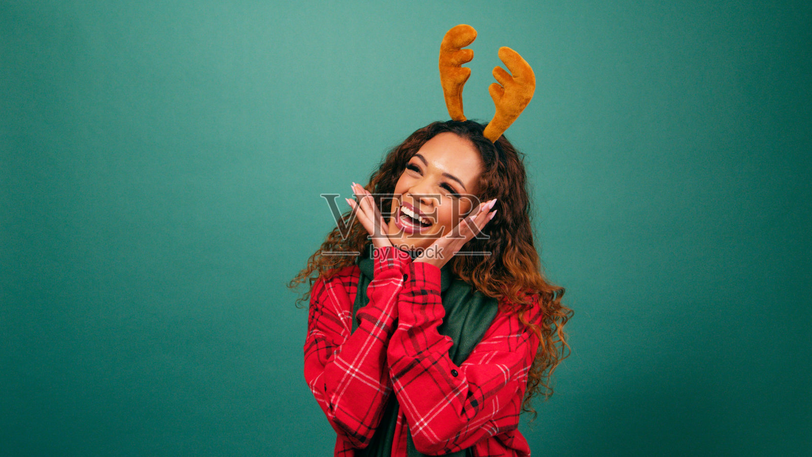 圣诞工作室,兴奋的年轻女子用手托着下巴摆出可爱的姿势照片摄影图片