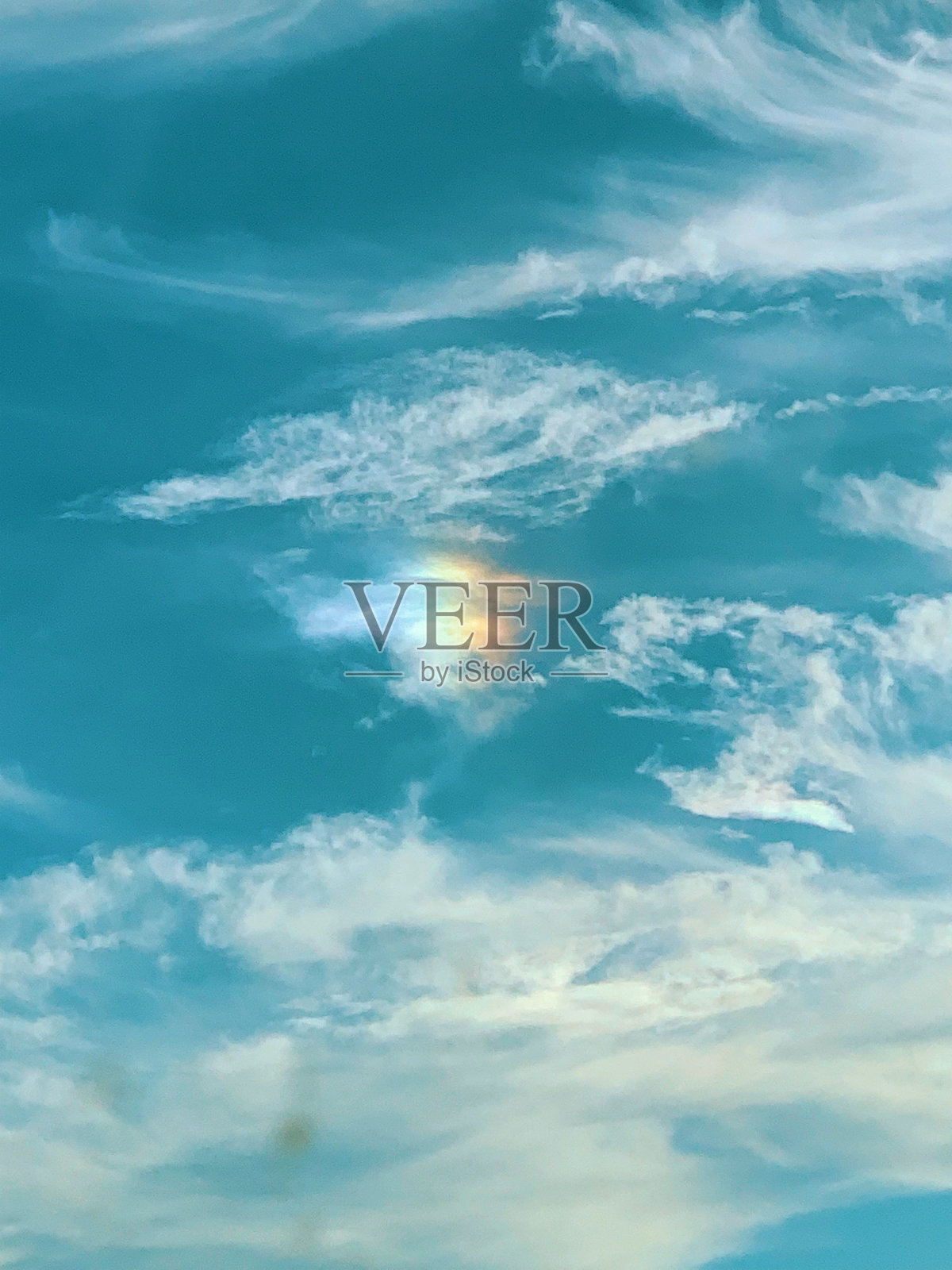 一条奇怪的彩虹出现在树线上方的蓝天上照片摄影图片