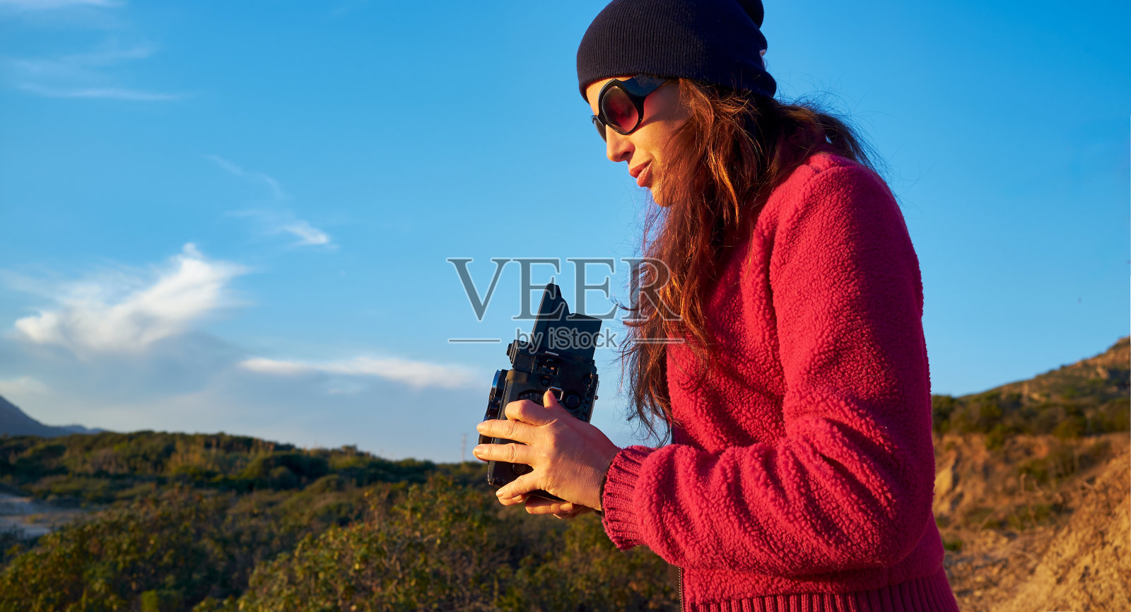 活跃的女人用老式6x6相机捕捉风景秀丽的山区景观。带有复制空间照片摄影图片