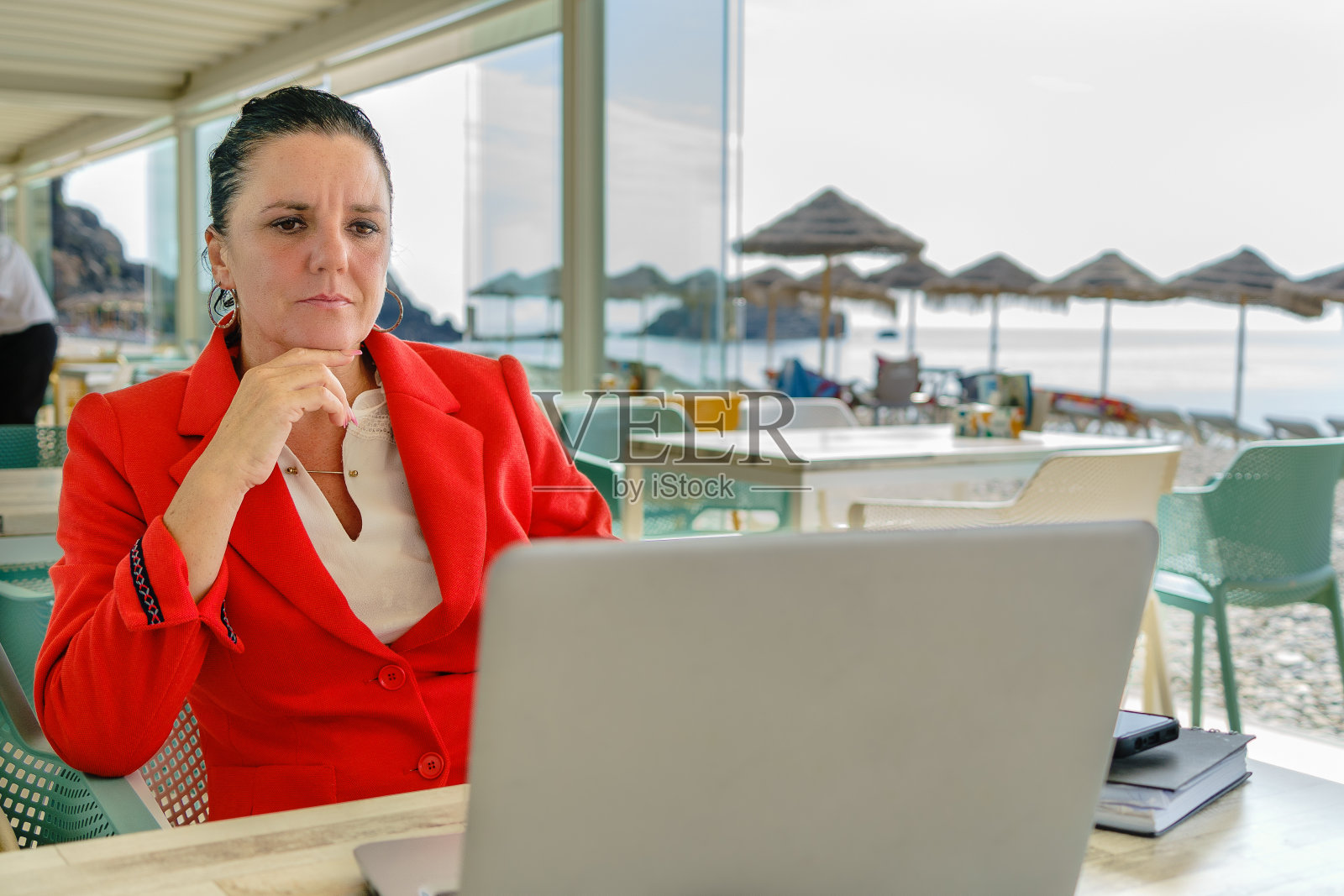 一位坐式远程办公的企业家在她的笔记本电脑前把餐厅当作办公室。照片摄影图片