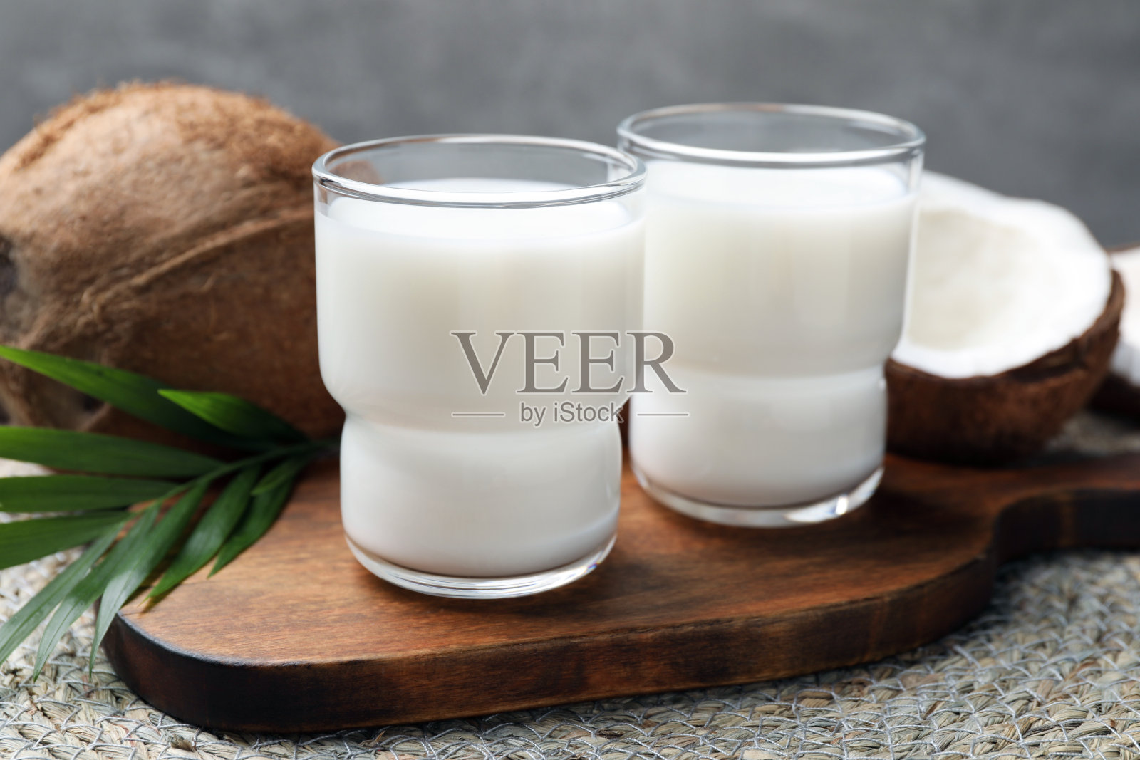 桌上有美味的椰奶、棕榈叶和椰子照片摄影图片