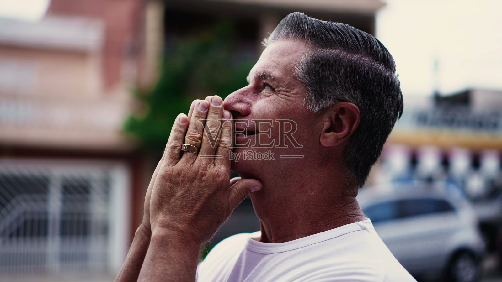 虔诚的老人在街上祈祷,带着希望和信念向天空微笑。心存感激的人照片摄影图片