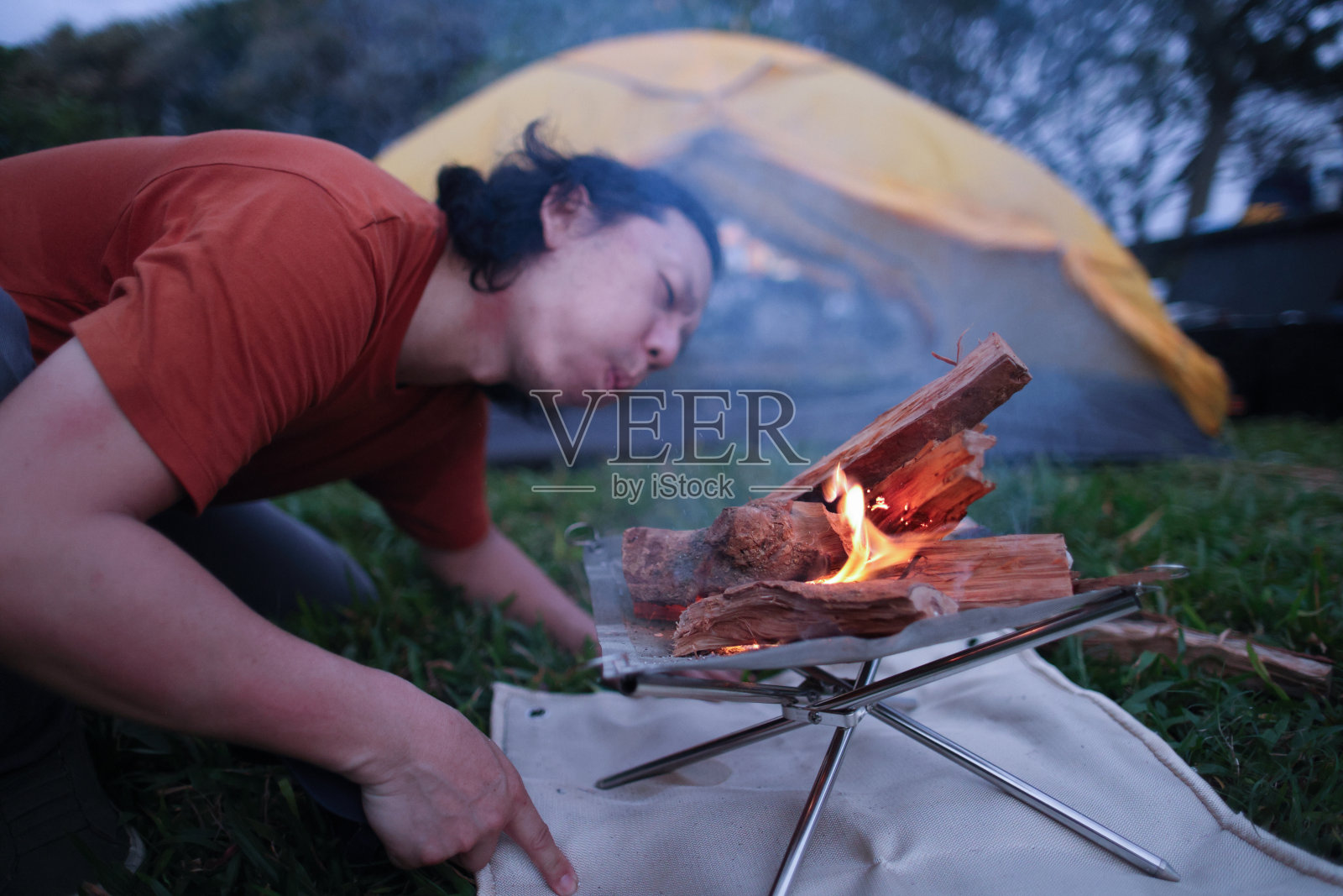 男子吹气助燃篝火照片摄影图片