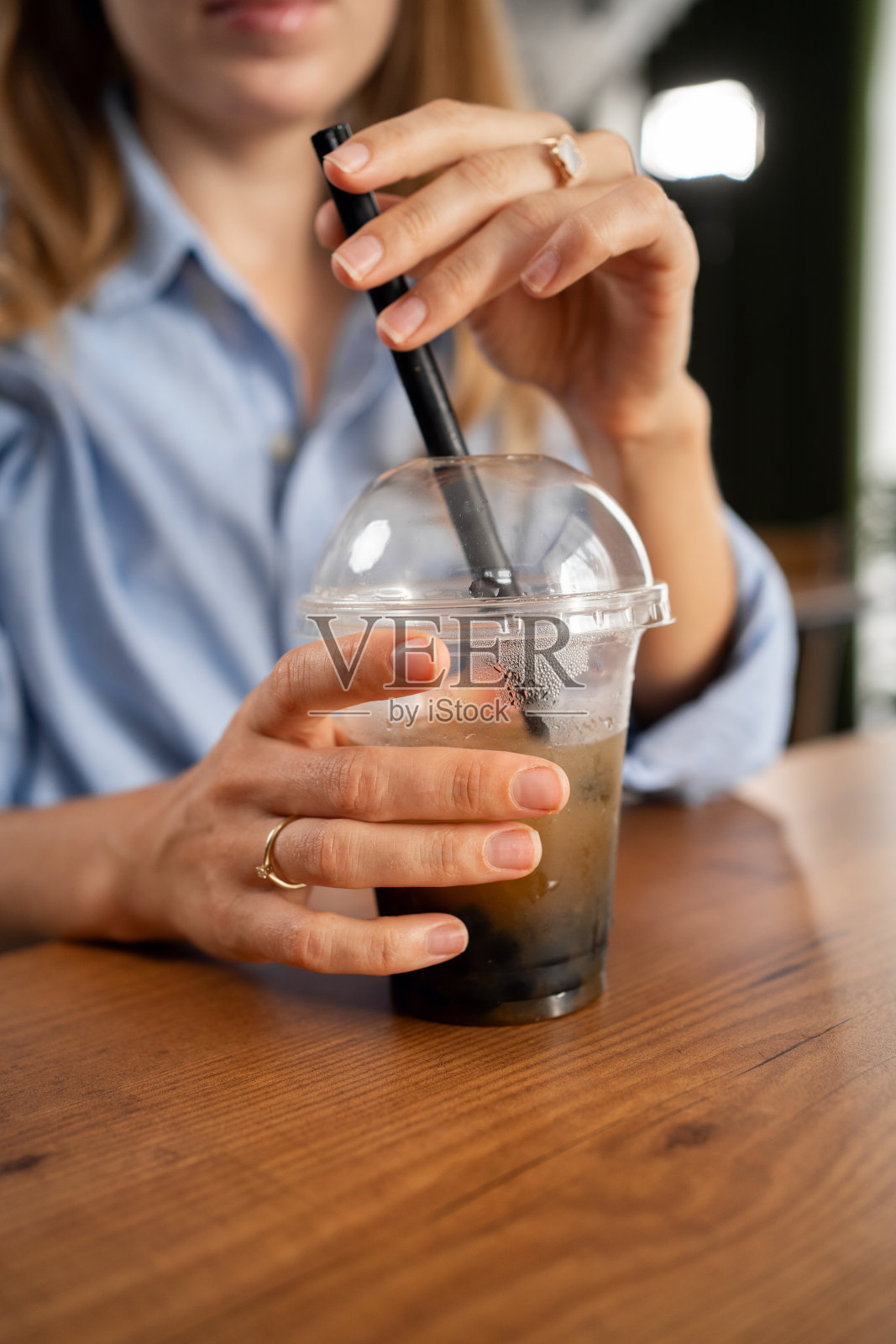 坐在咖啡馆里喝珍珠奶茶的女人照片摄影图片