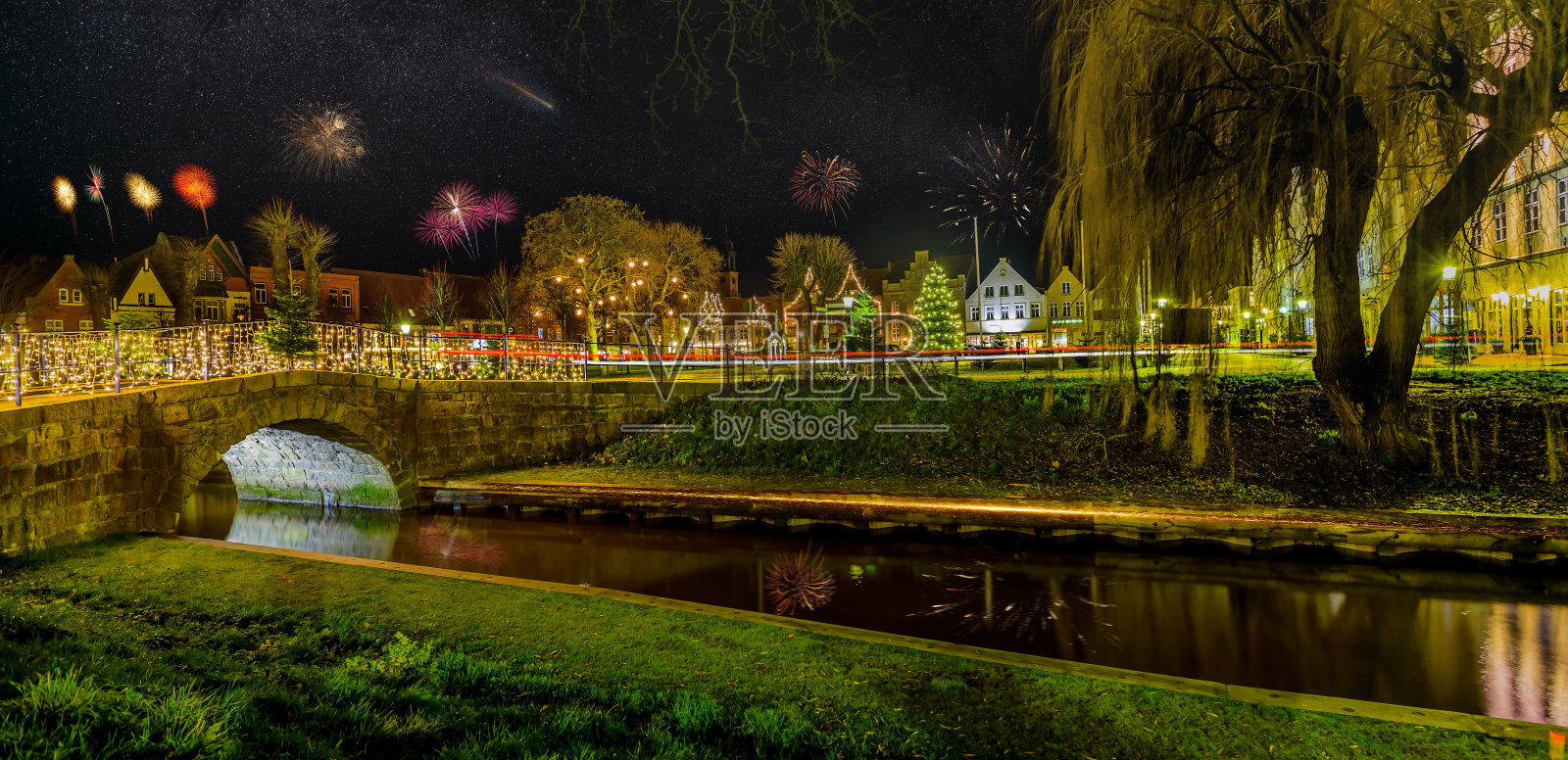 烟花,节日灯光和新年浪漫气氛在弗里德里希施塔特的夜晚。欧洲德国石勒苏益格-荷尔斯泰因,新年时弗里德里希城的夜景。照片摄影图片