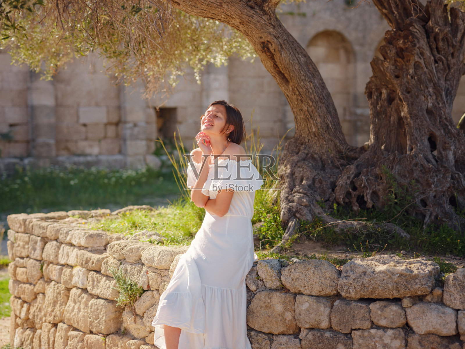 美丽的亚洲年轻女子在户外穿着白色连衣裙照片摄影图片