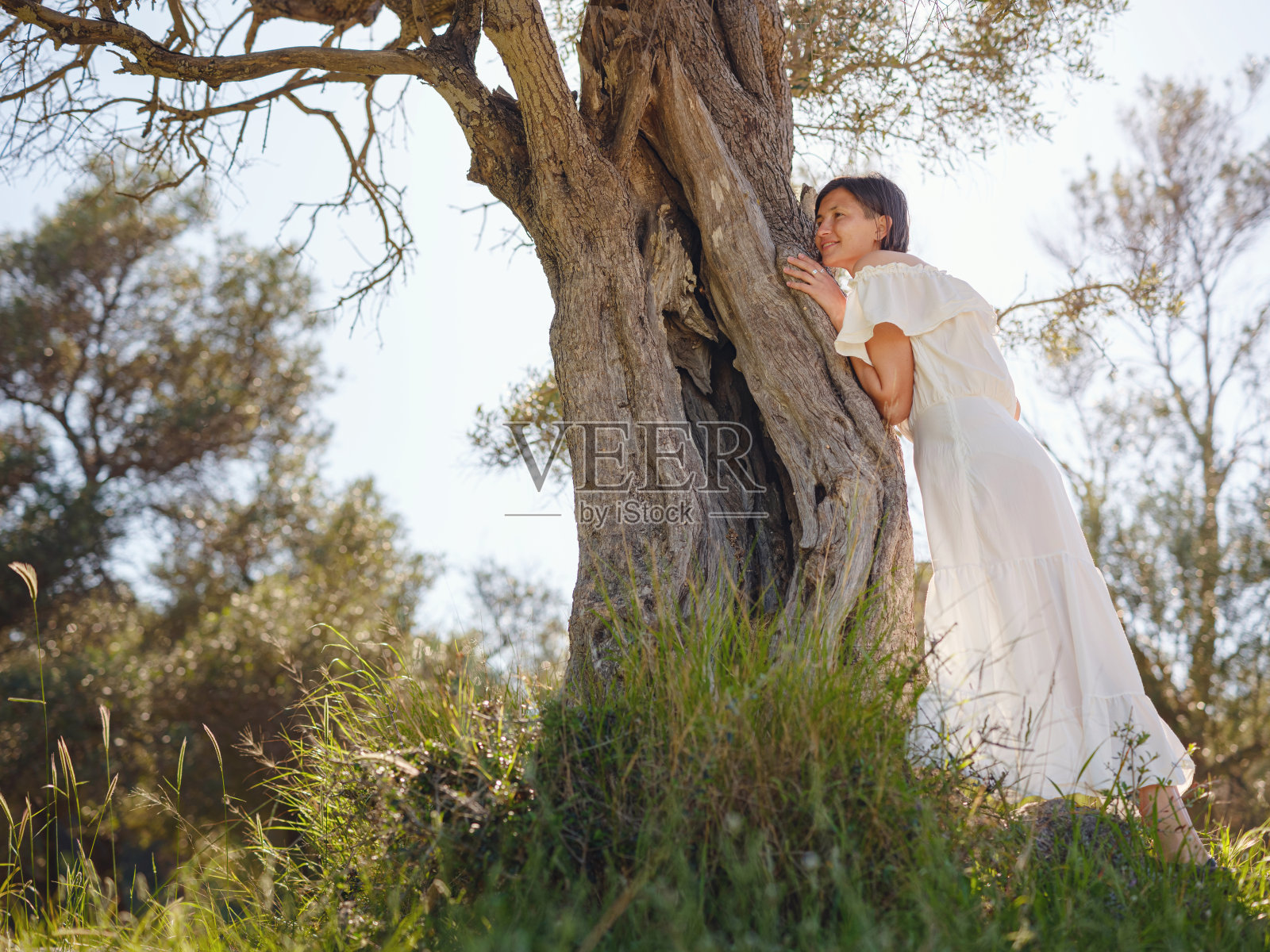 美丽的亚洲年轻女子在户外穿着白色连衣裙照片摄影图片