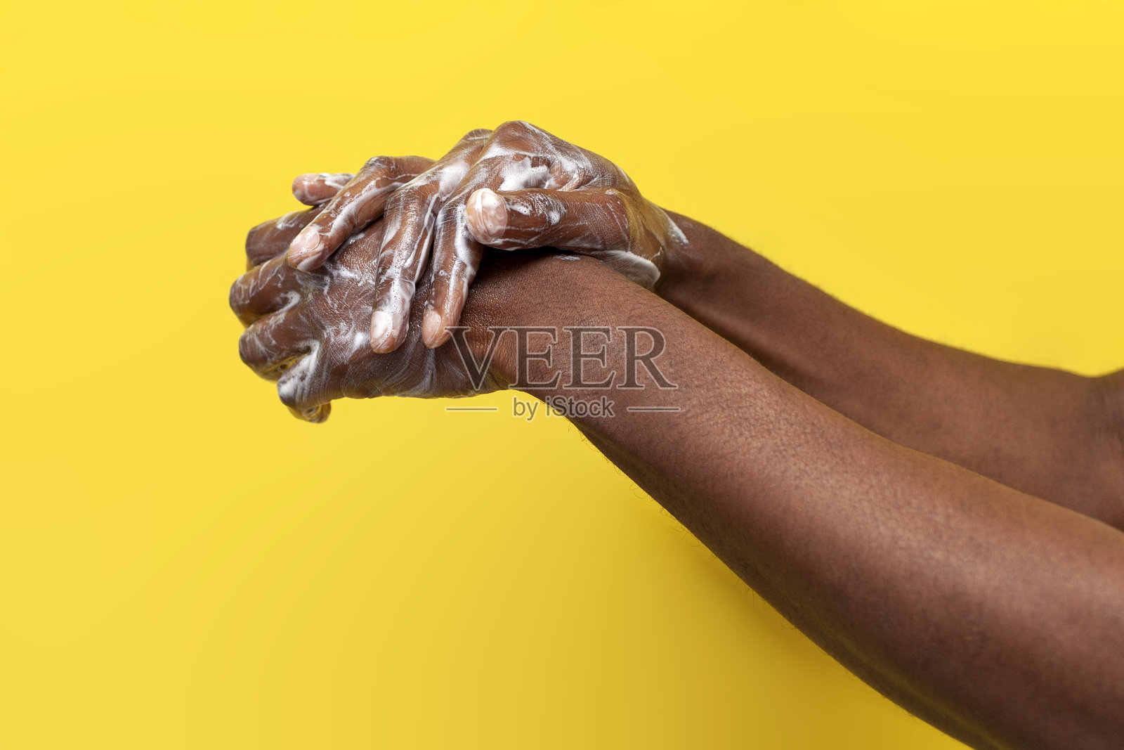 非裔美国人的手在黄色孤立背景上用肥皂和泡沫洗手照片摄影图片