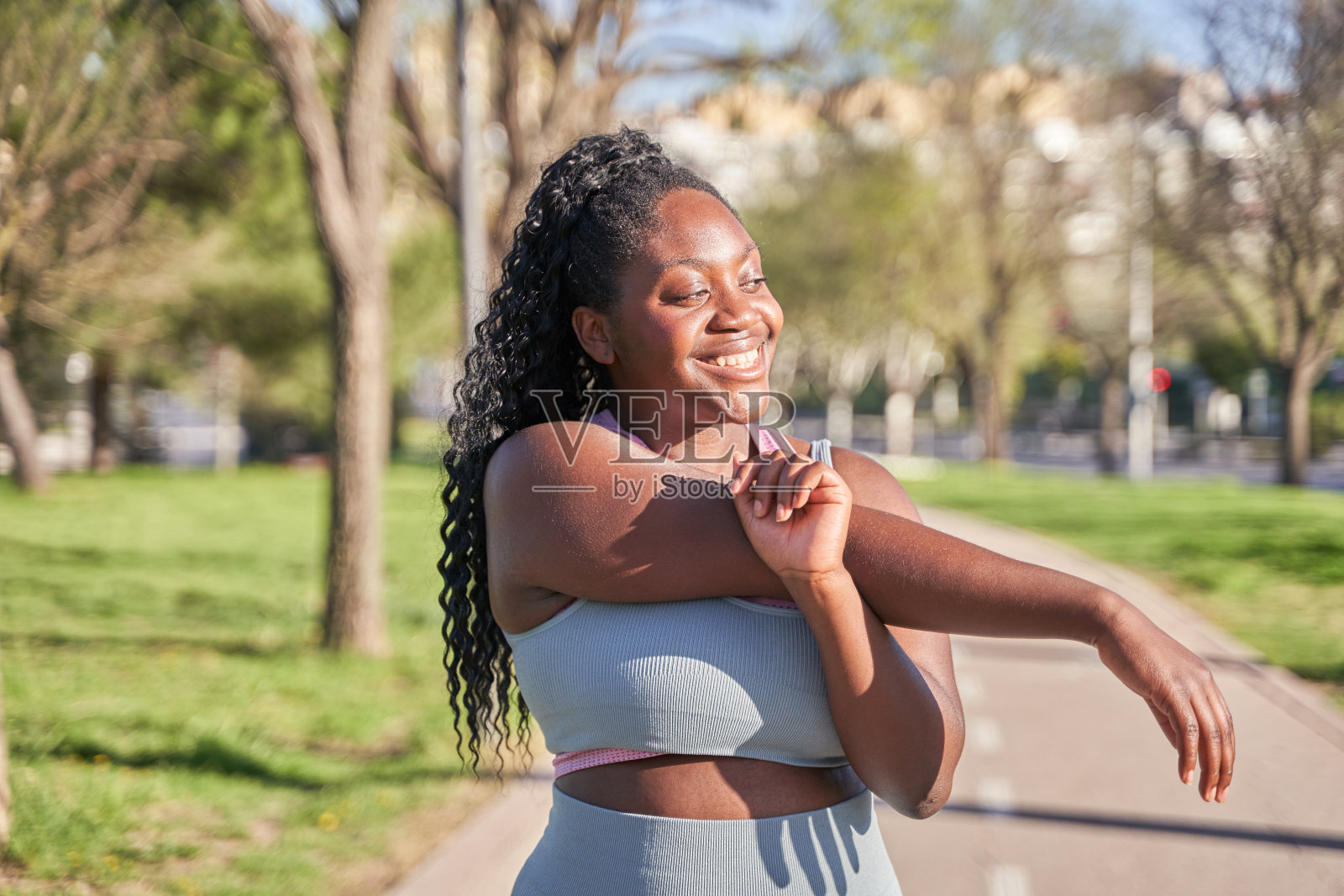 迷人的年轻女子在晨练前热身,伸展双臂。健身、运动、健康的生活理念照片摄影图片