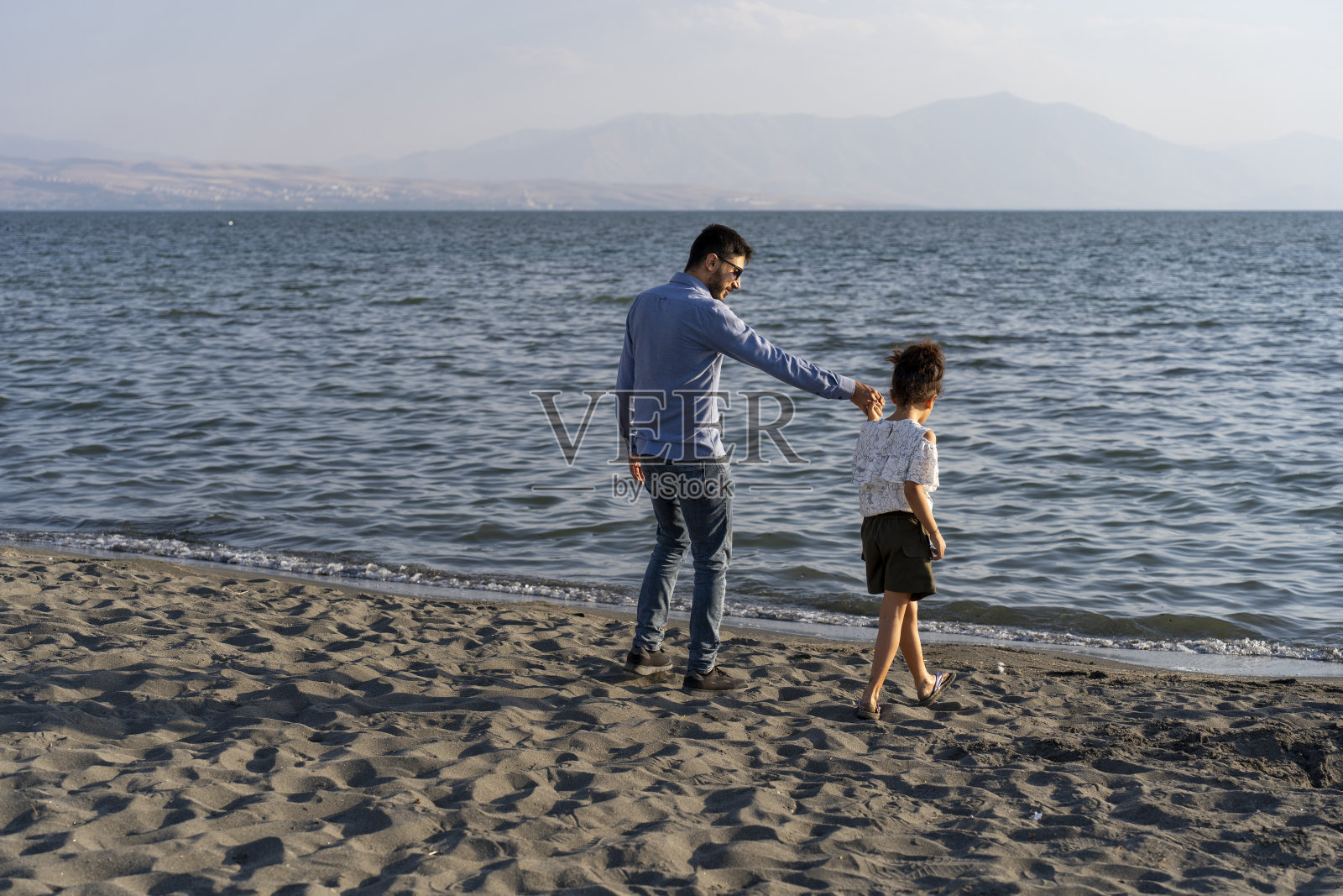 父女在沙滩上散步,父亲节概念照片摄影图片