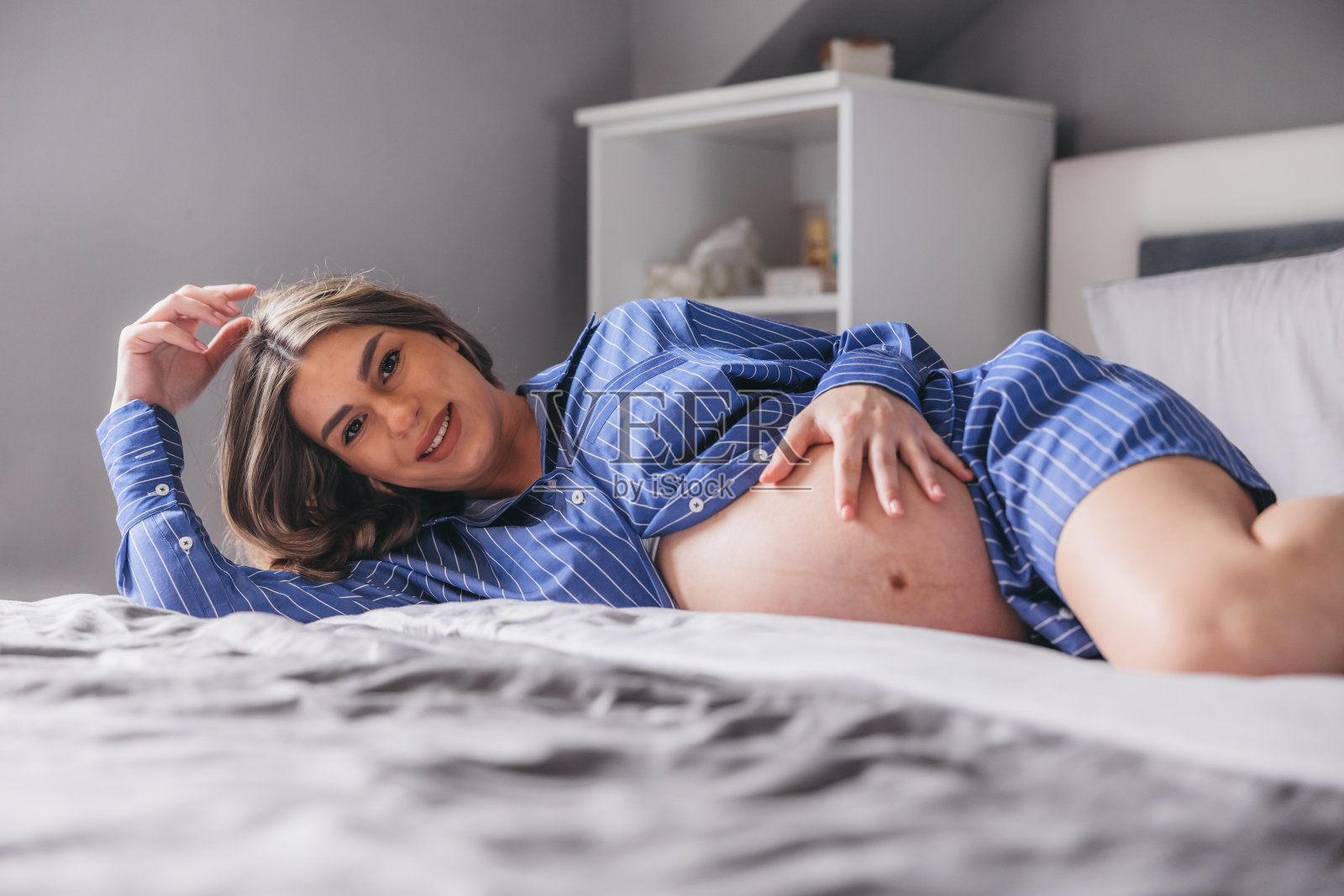 年轻漂亮的孕妇在卧室里摆姿势照片摄影图片