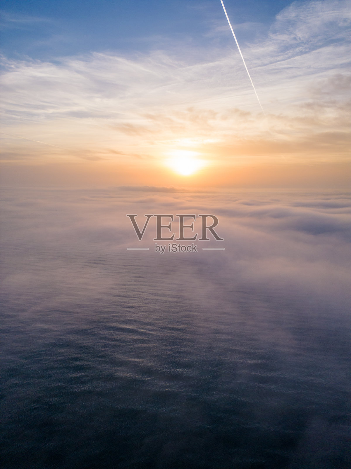 鸟瞰图,日出的海面上笼罩着晨雾和早晨的阳光照片摄影图片