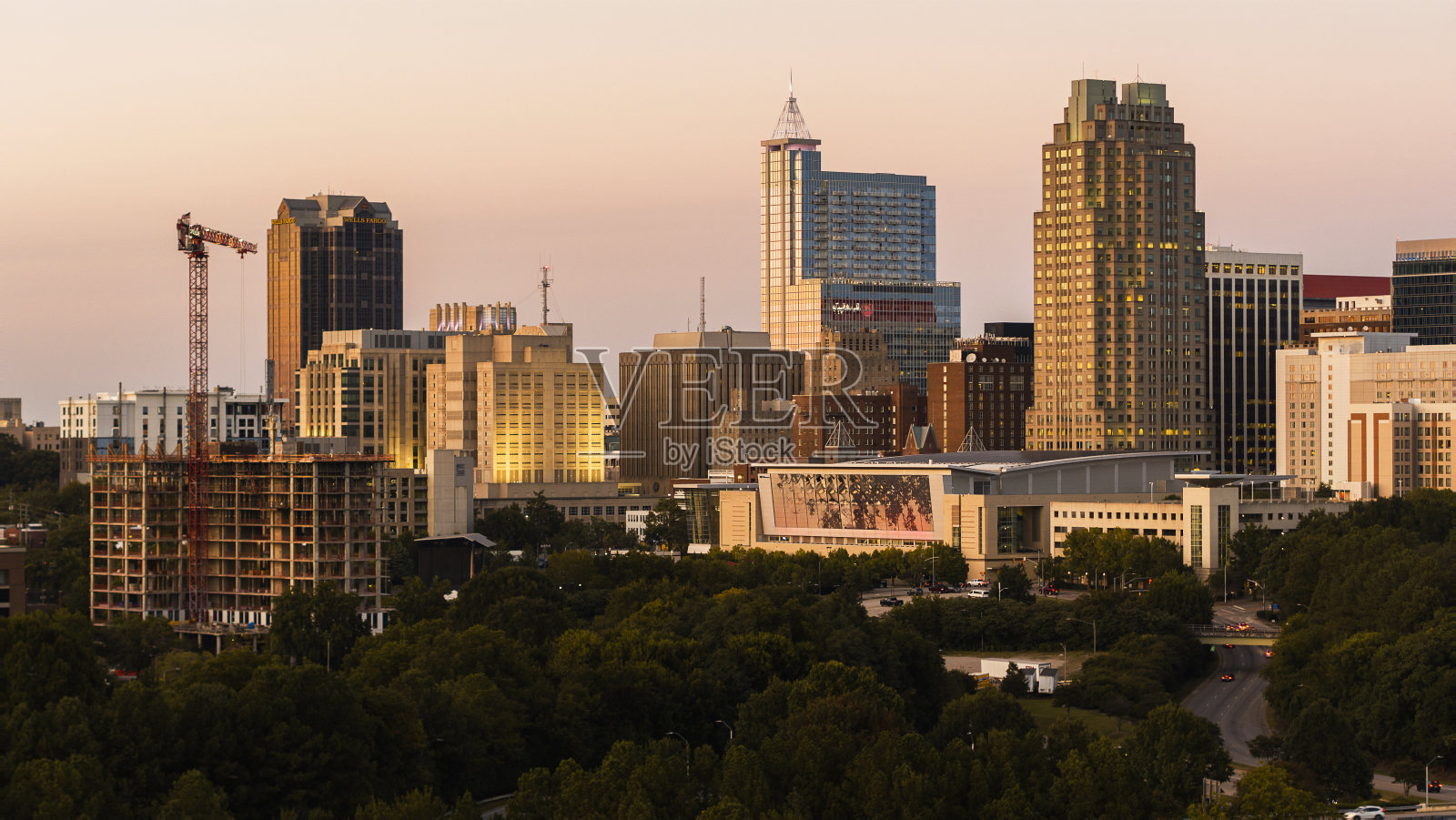 北卡罗来纳州罗利市的金色地平线:日落下的建筑工地和罗利市中心天际线照片摄影图片