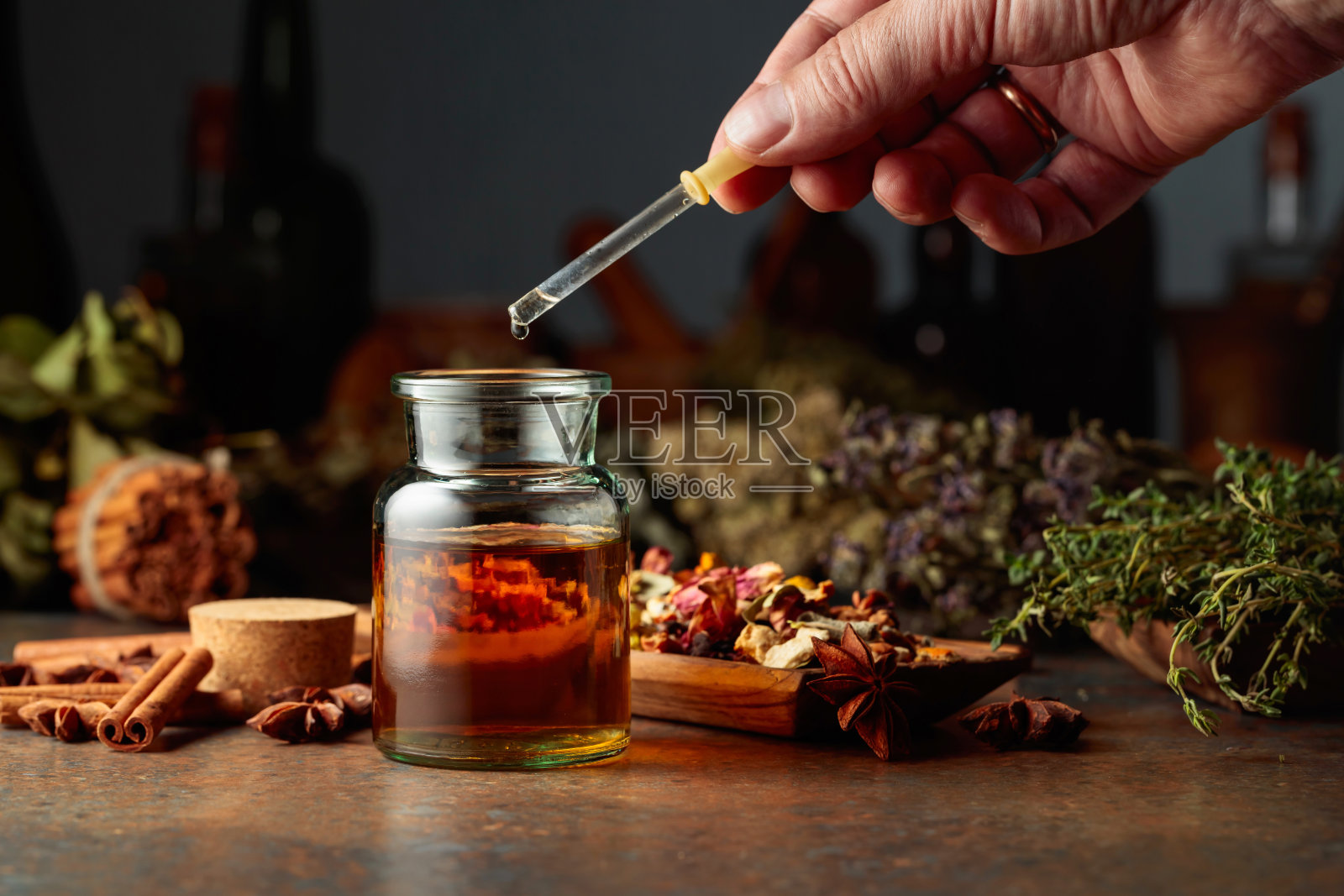 将草药酊剂滴入小玻璃瓶。照片摄影图片