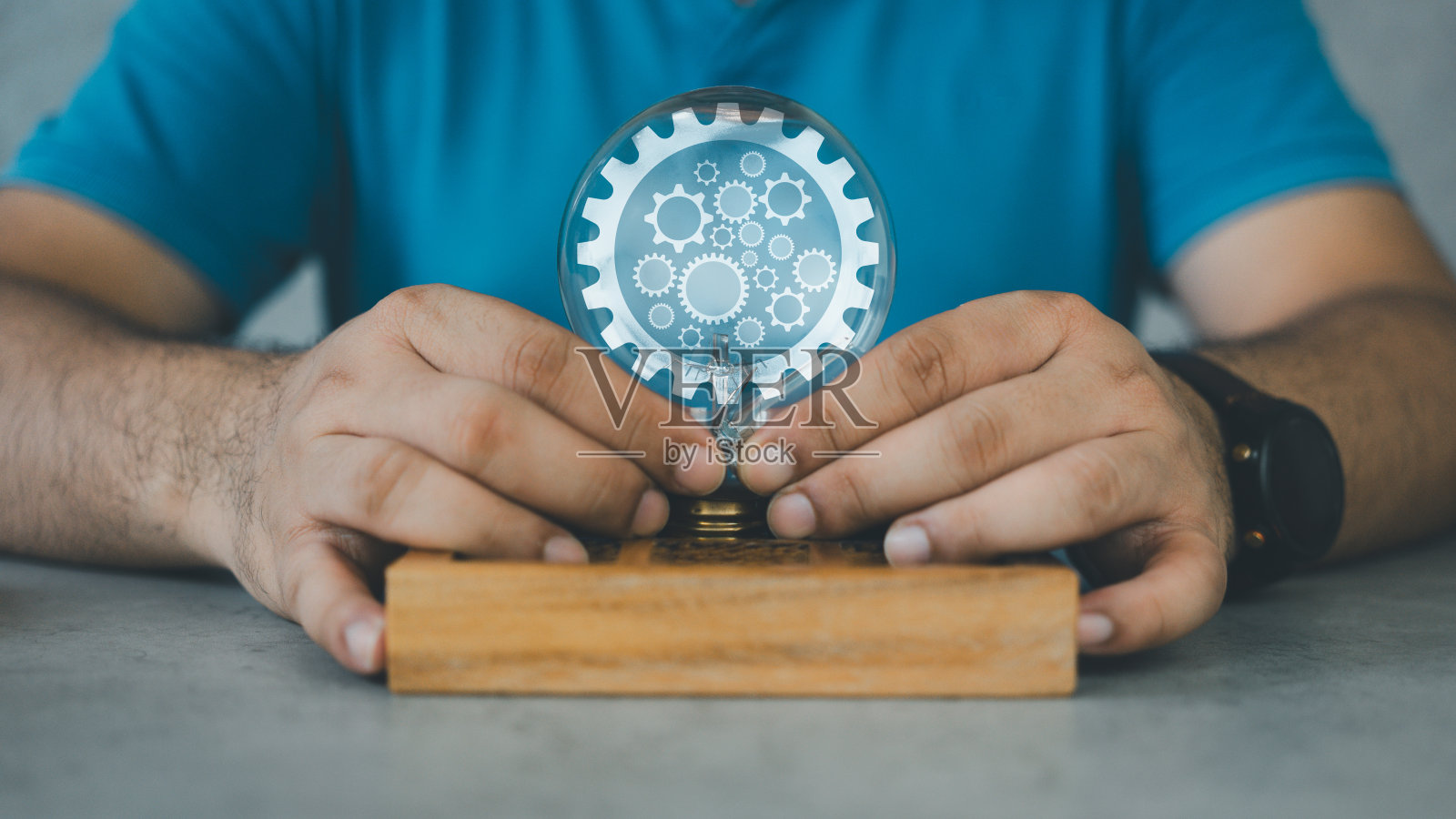 人手里拿着灯泡,里面装着齿轮,解决概念、发明、发展。照片摄影图片