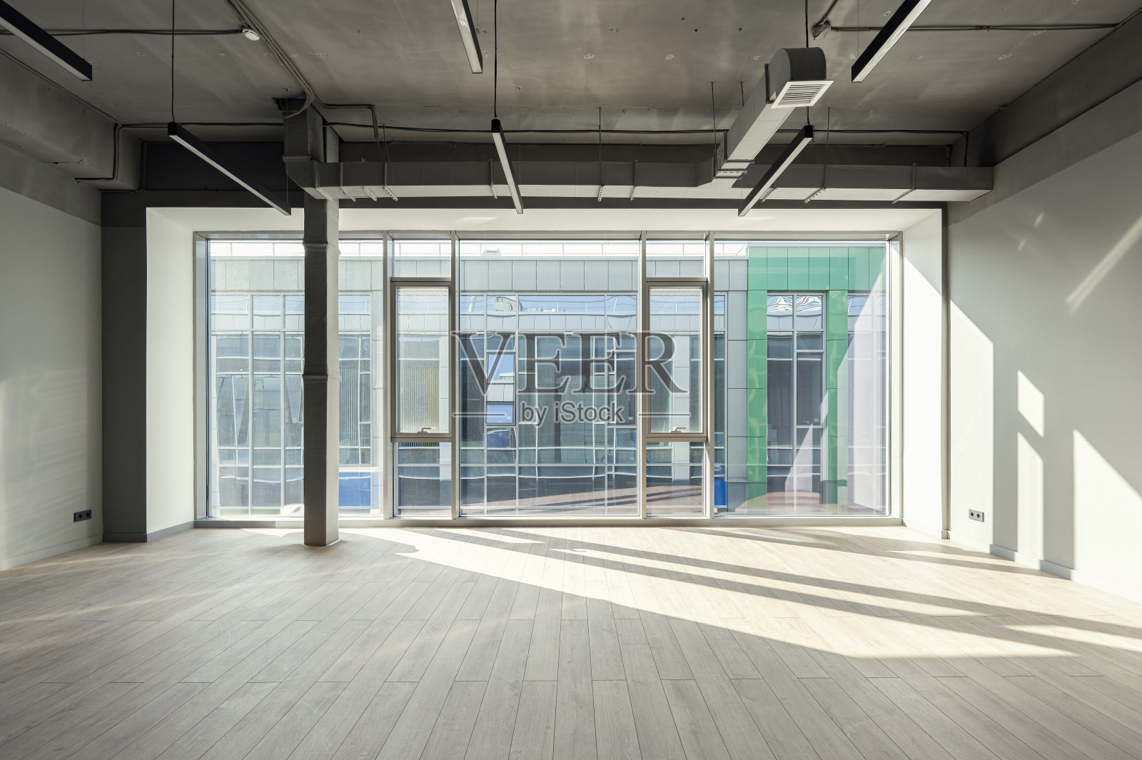 一个充满阳光的空工作区。巨大的全景窗照片摄影图片