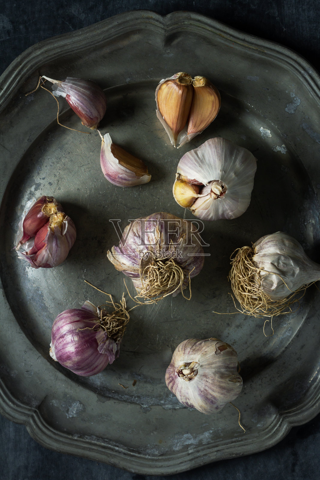 生大蒜放在灰色的锡盘子里照片摄影图片