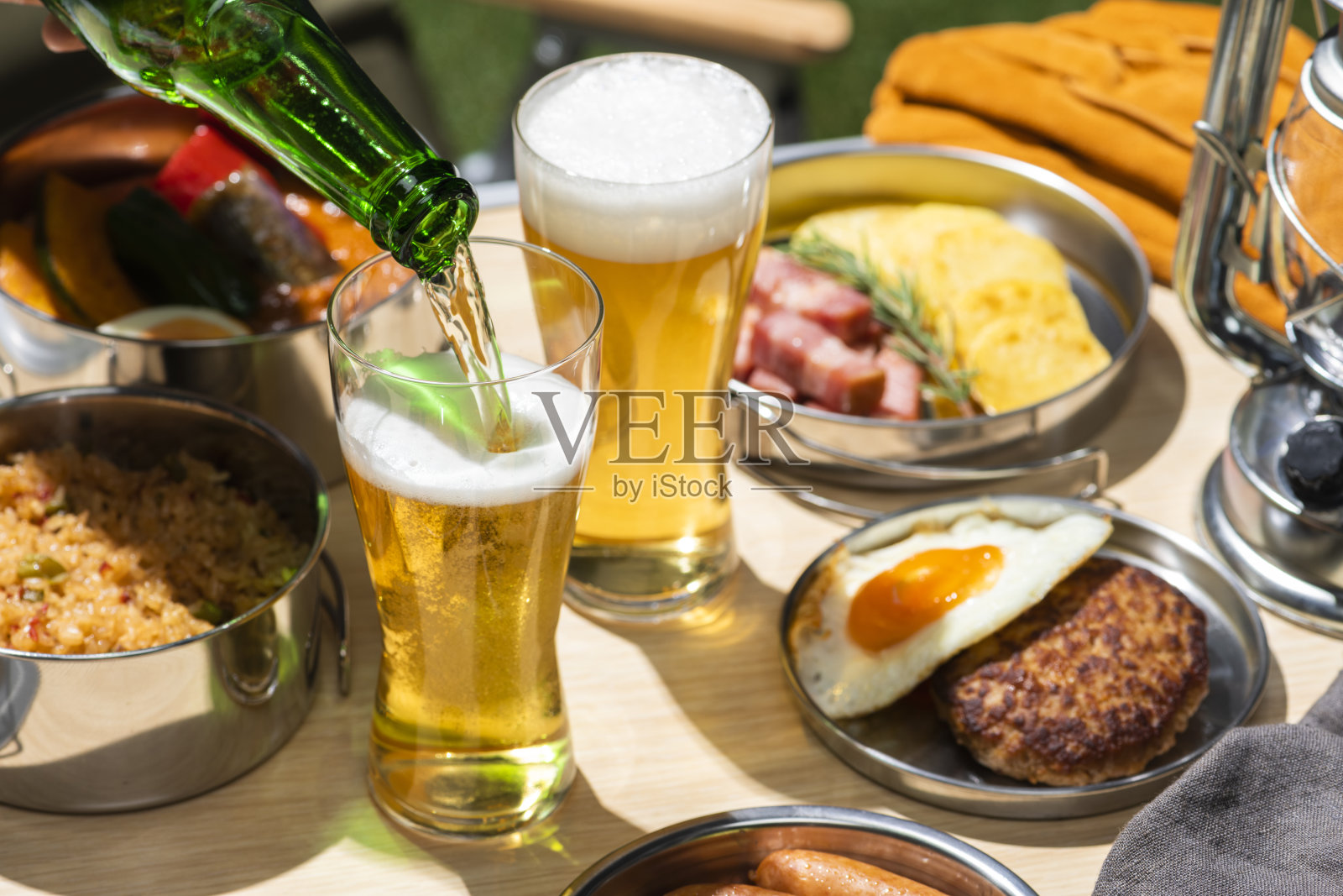 户外露营桌上的美味佳肴和清爽啤酒照片摄影图片