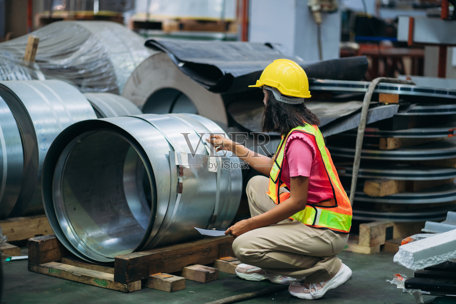 在工厂机器前检查机器的工人。在钣金公司工作的技术员。领班检查材料或机器。照片摄影图片