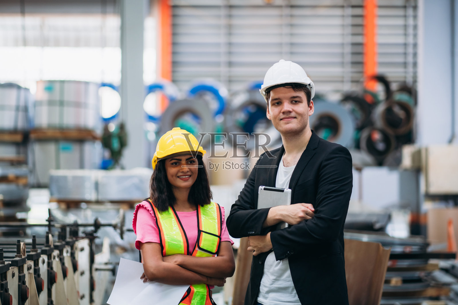 快乐的产业工人看着工厂机器的照片。工业钣金技术人员。照片摄影图片