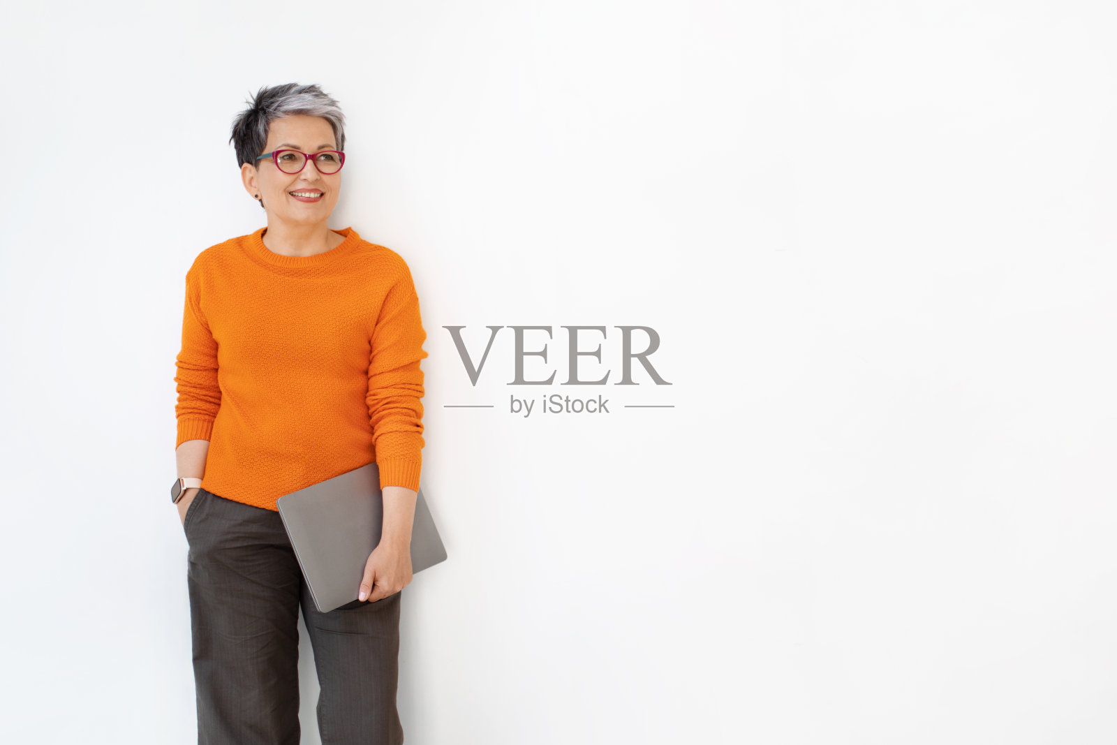 中年女人穿着便装拿着笔记本电脑,白色背景照片摄影图片