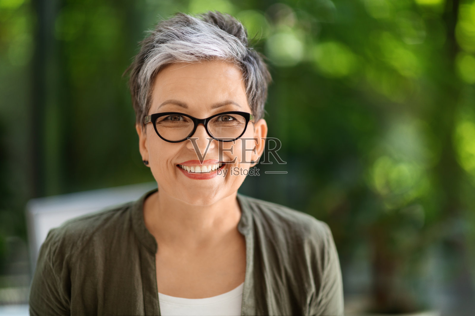 幸福的中年女商人在办公室摆姿势的肖像照片摄影图片