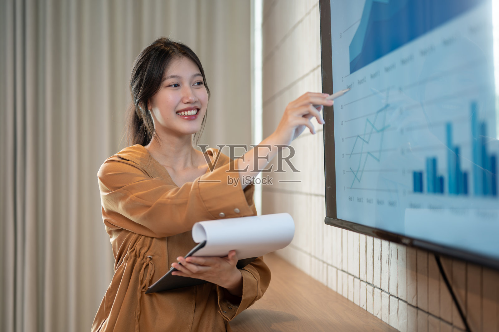 一位聪明的亚洲女商人正在会议上展示她的财务分析资料。照片摄影图片