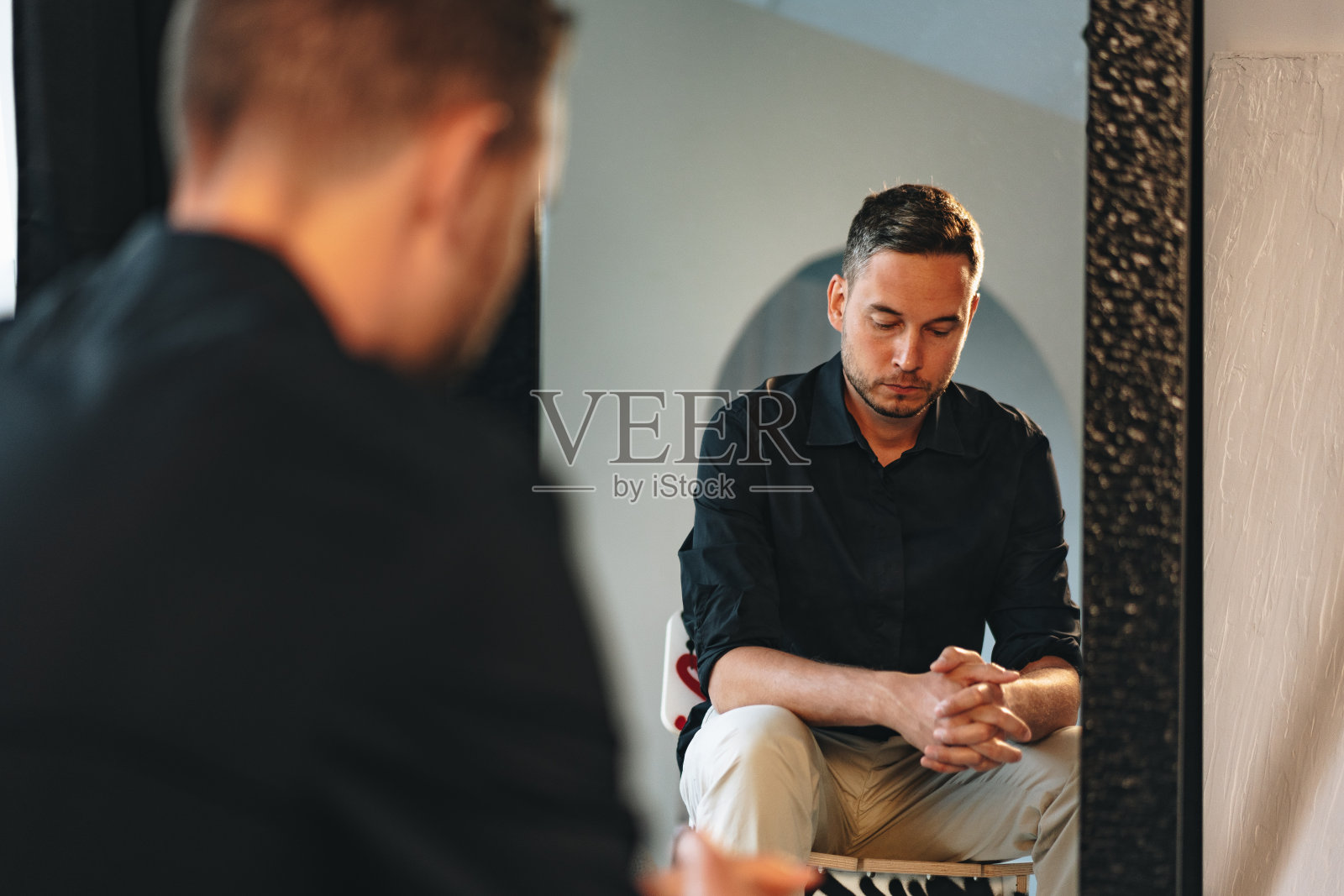 年轻人看着镜子里的自己照片摄影图片