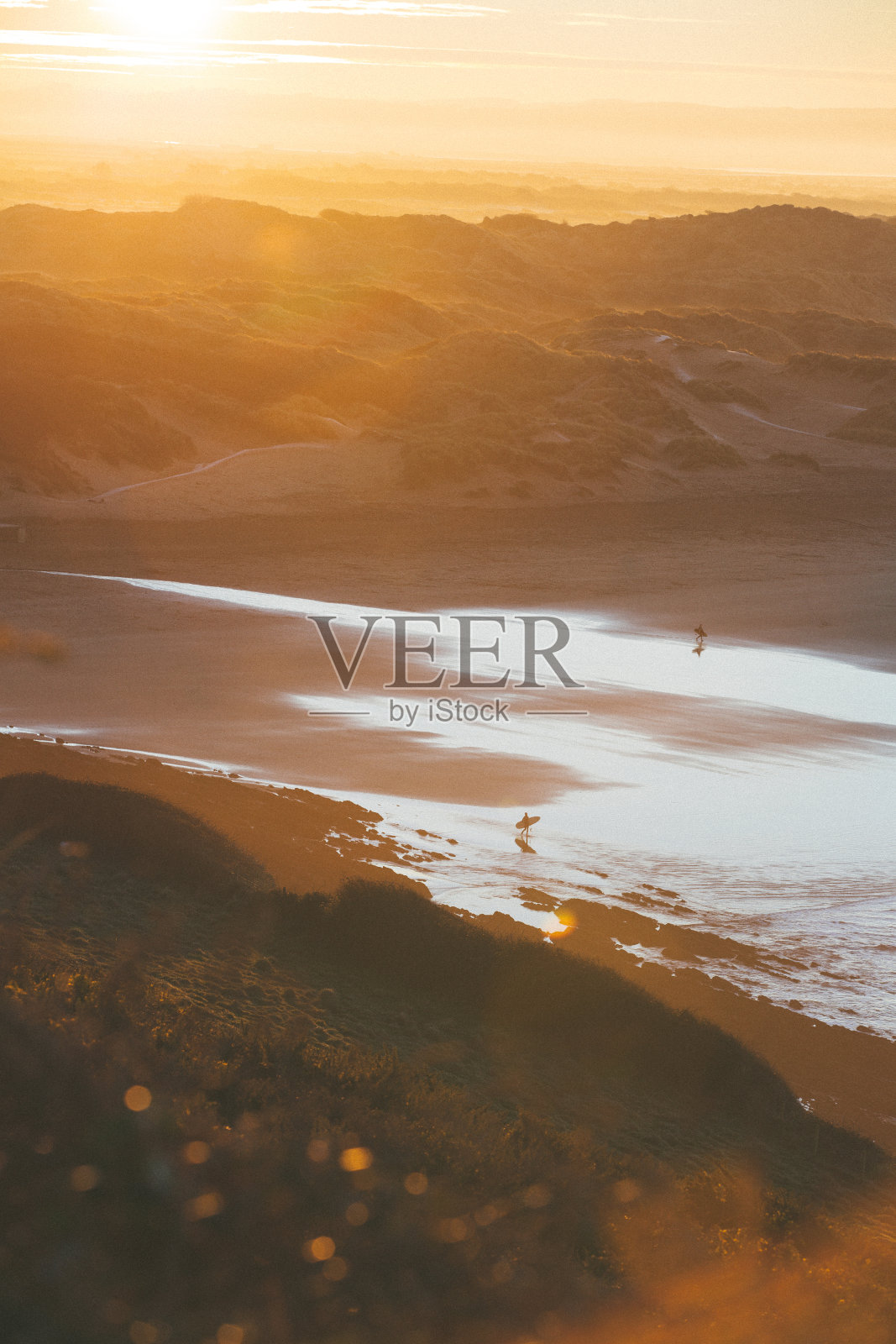 两个冲浪者在美丽的阳光下走向大海的宁静时刻照片摄影图片