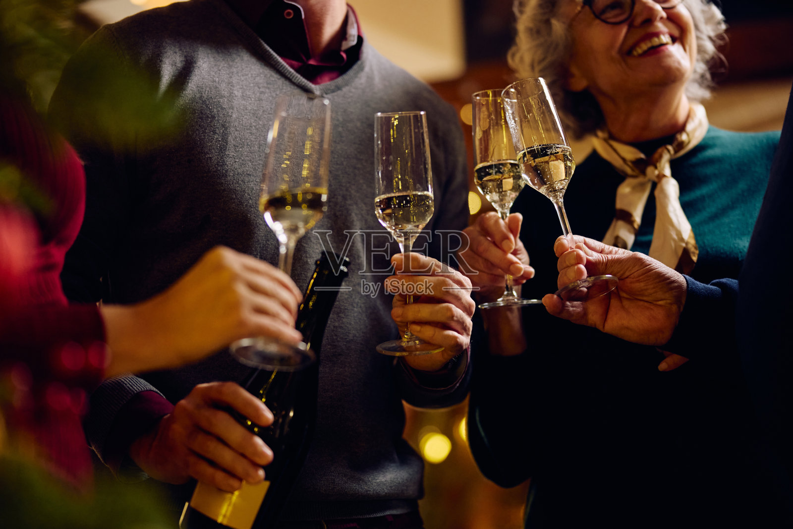 圣诞节庆祝活动中,家人举杯共饮香槟的特写。照片摄影图片