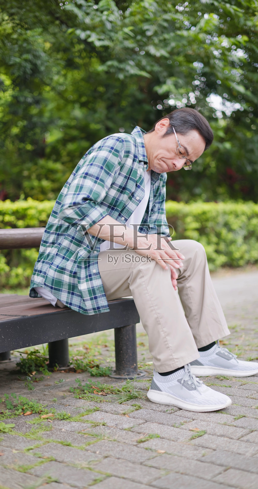 男人抚摸他疼痛的膝盖照片摄影图片