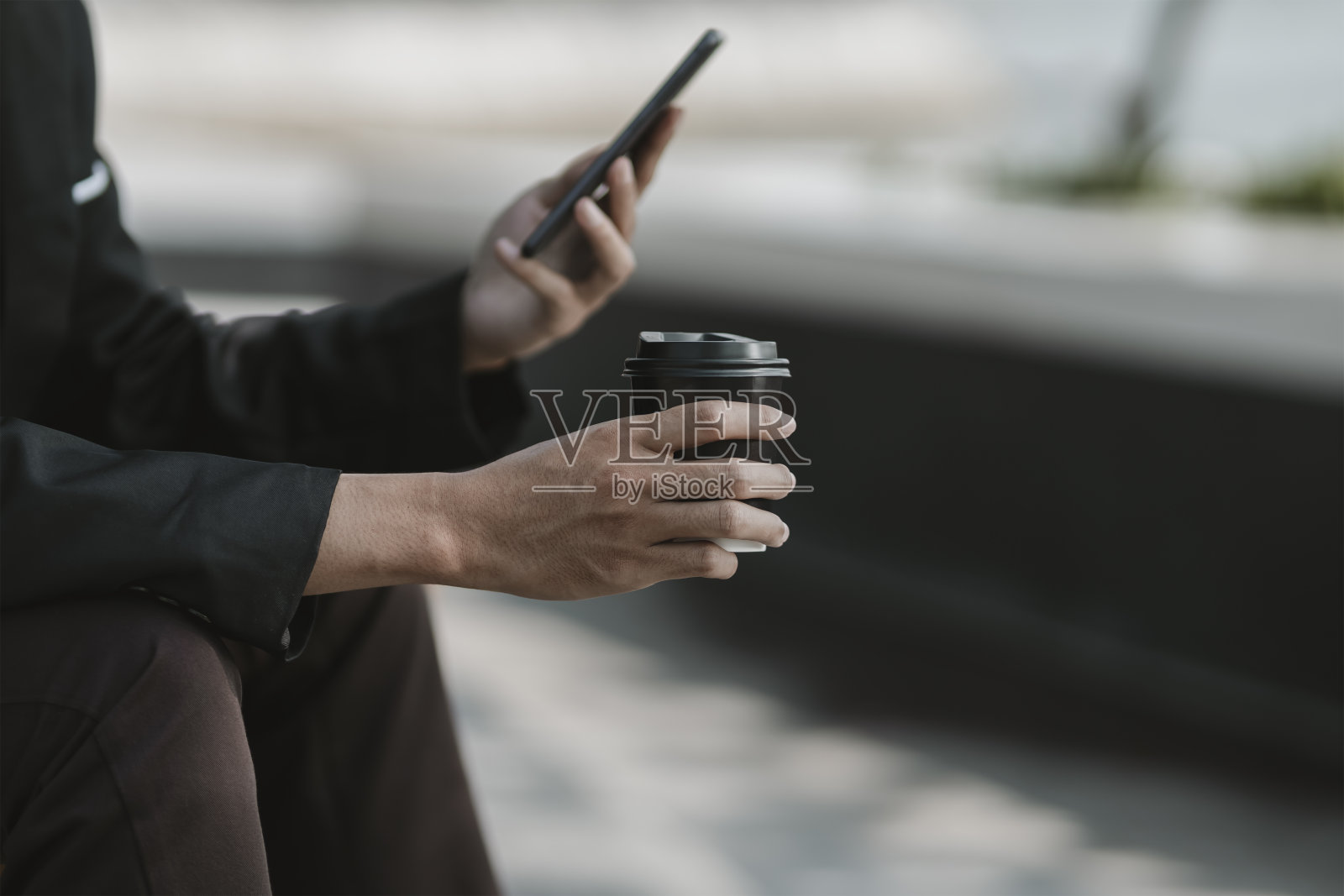 被解雇或辞职的员工拿着热咖啡,用手机搜索工作。失业、招聘、辞职概念照片摄影图片