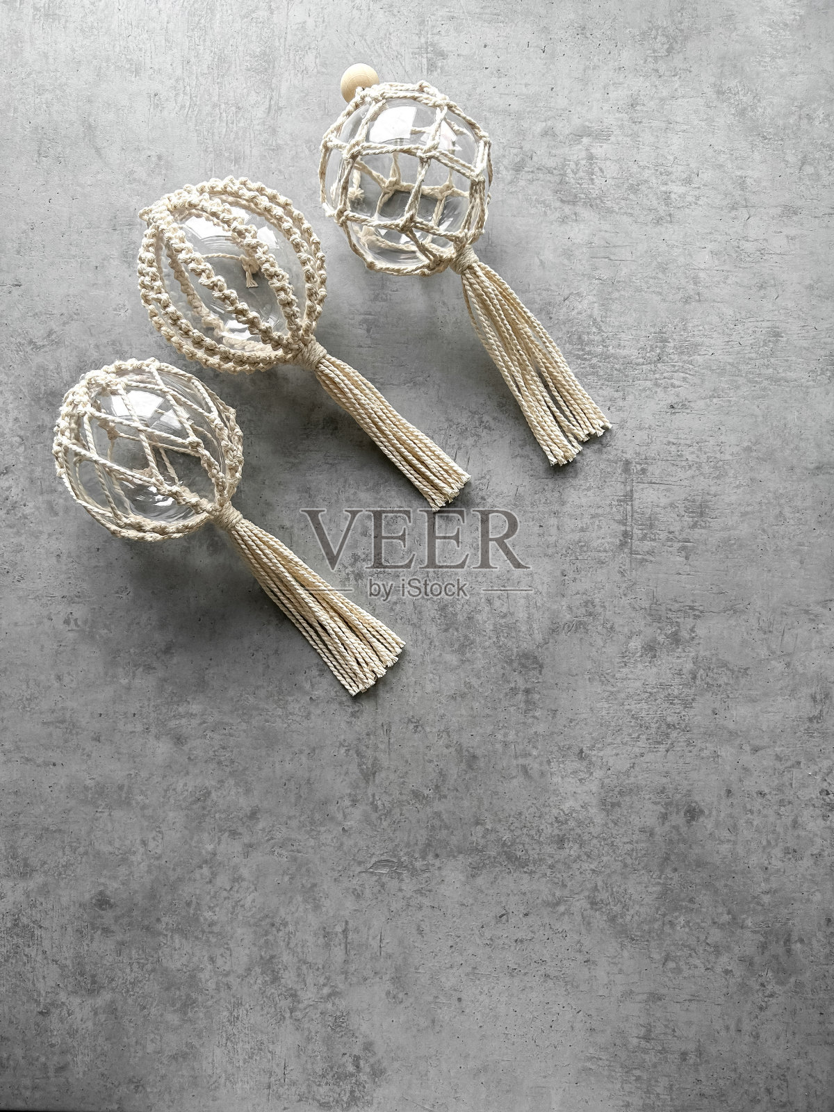 透明的圣诞球编织在流线风格,手工装饰在生态风格,顶视图在灰色背景。圣诞、新年和环保理念。照片摄影图片