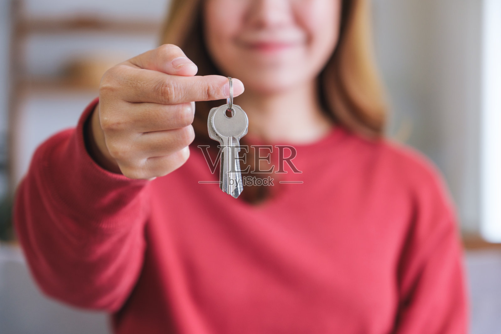 一个女人拿着房地产概念的钥匙的特写图像照片摄影图片