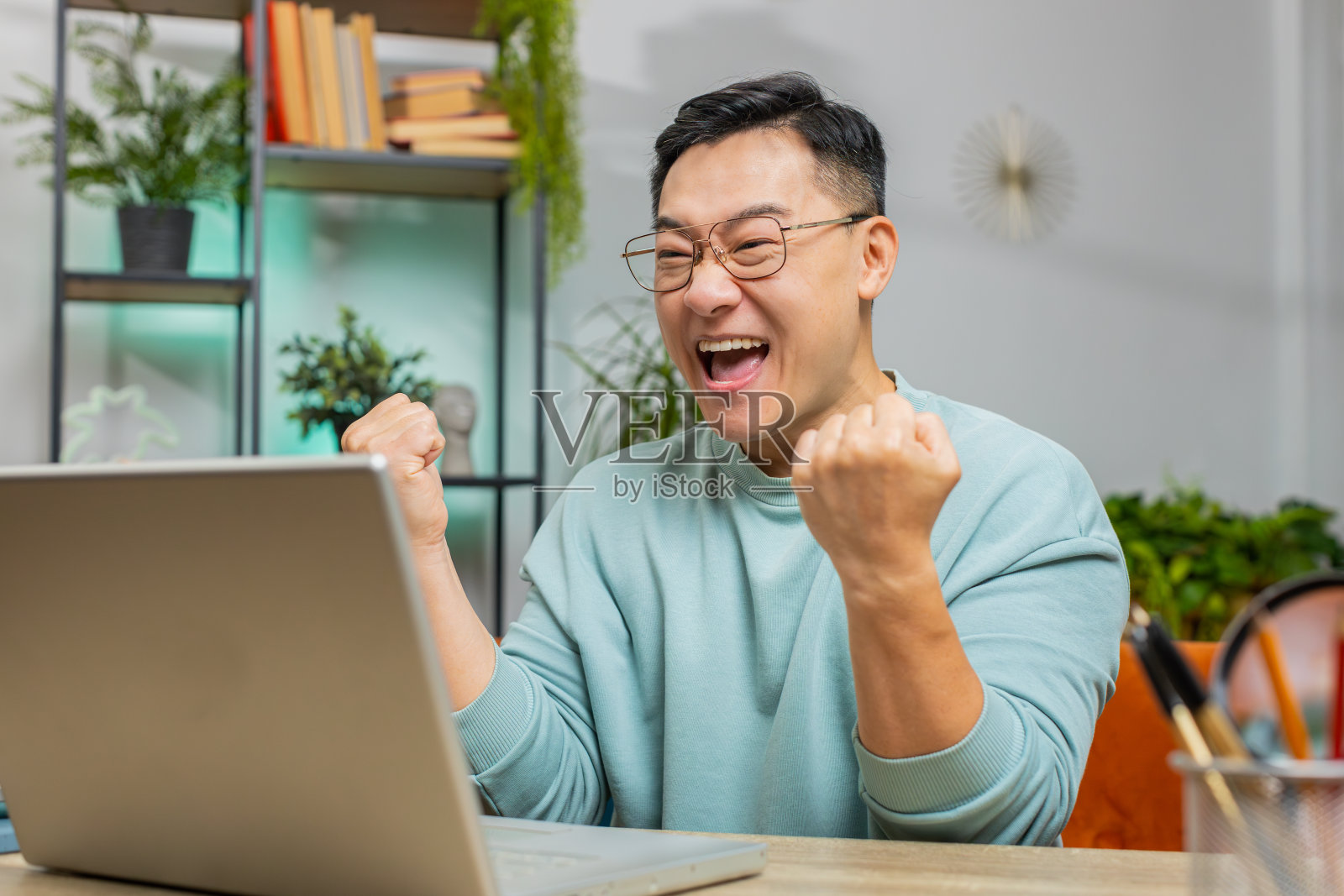 惊奇的亚洲人使用笔记本电脑,收到喜讯喜讯,喜闻乐见,庆祝胜利照片摄影图片