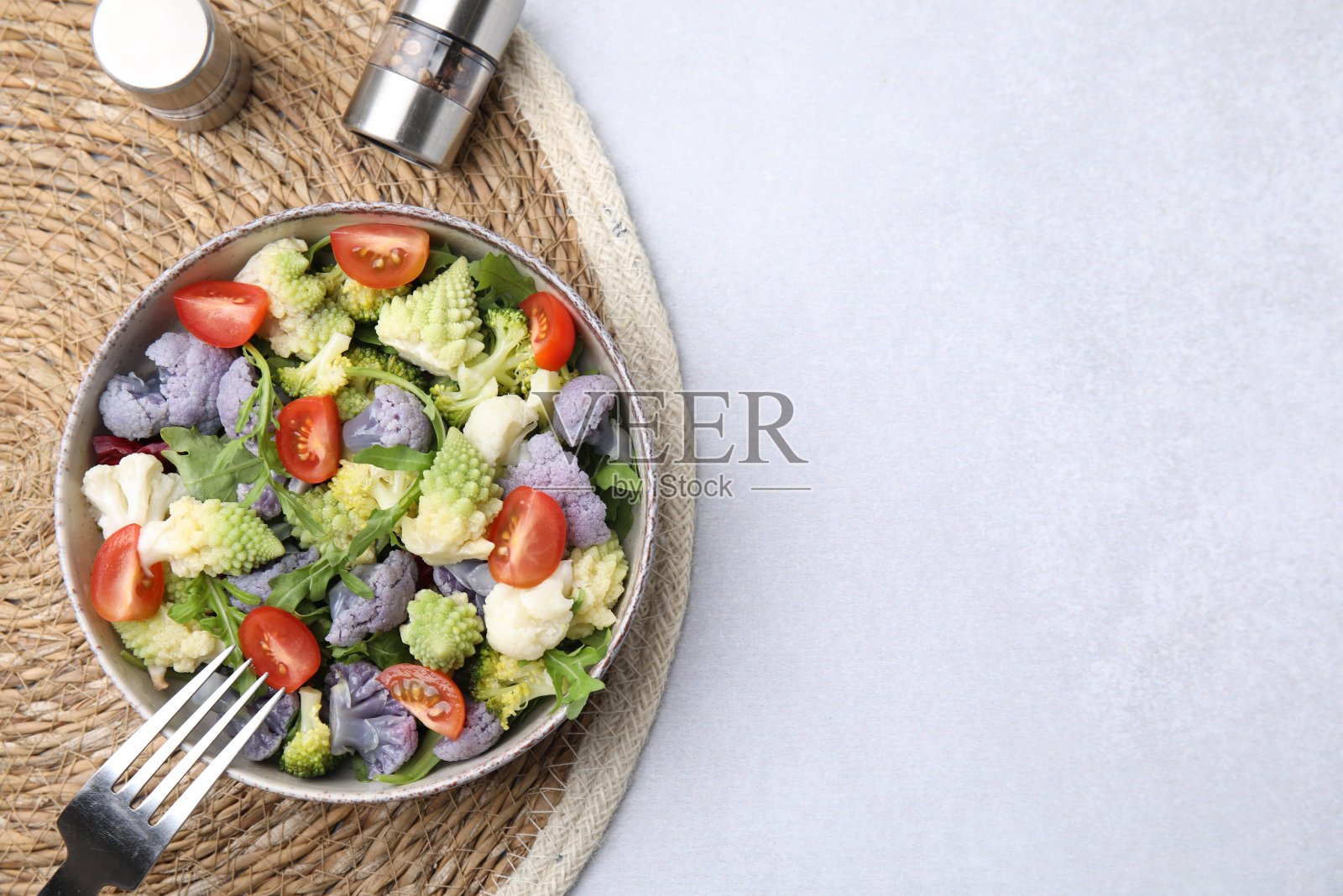 美味的花椰菜和番茄沙拉,在白色的桌子上,平铺。文本空间照片摄影图片